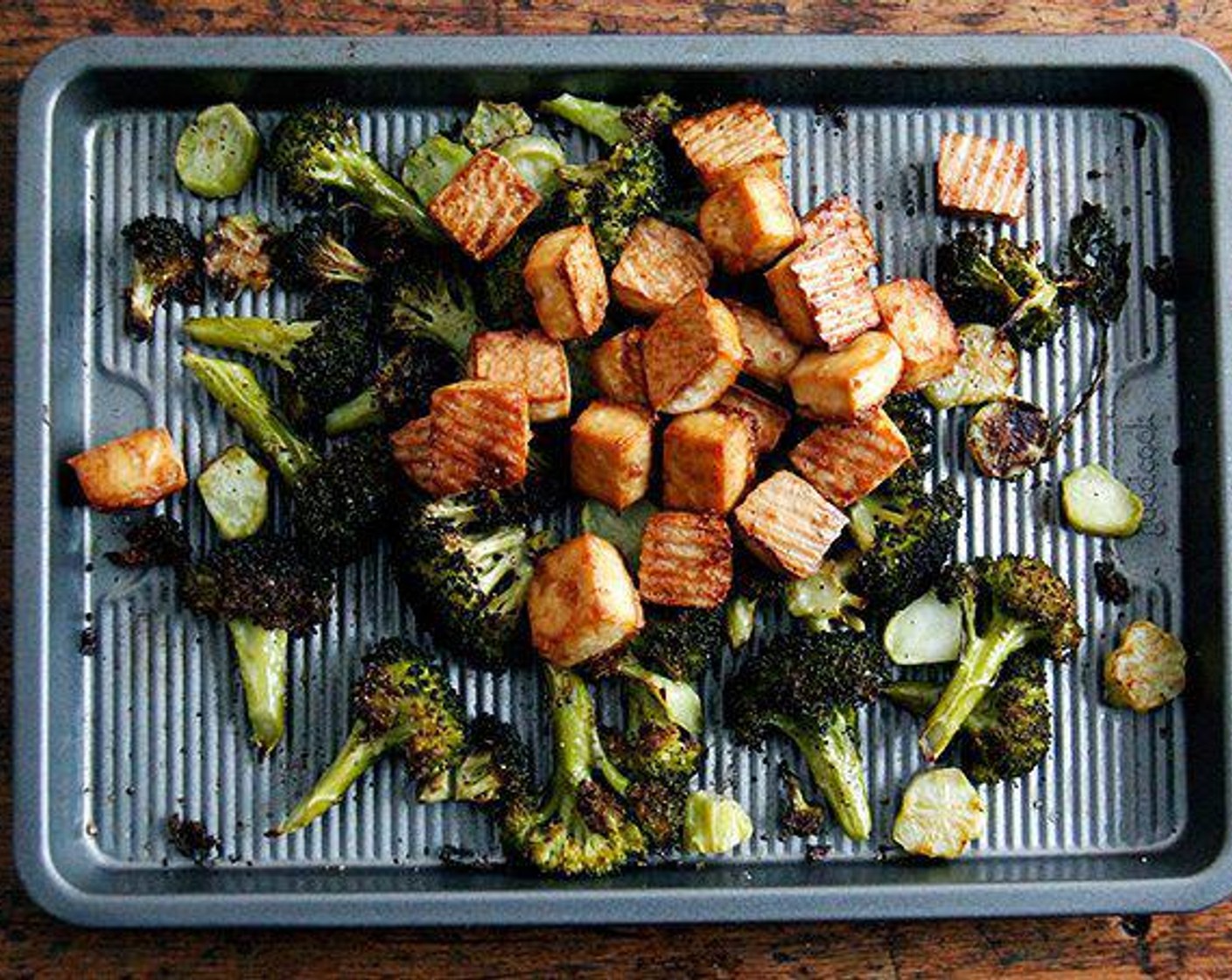 step 6 Cook the tofu and broccoli: Place both sheet pans in the oven and roast for 20 minutes, then toss the pieces around for even coloring and roast another 10 minutes. At this point, the tofu is usually done, which is to say golden at the edges and lightly crisp. Remove the pan from the oven.