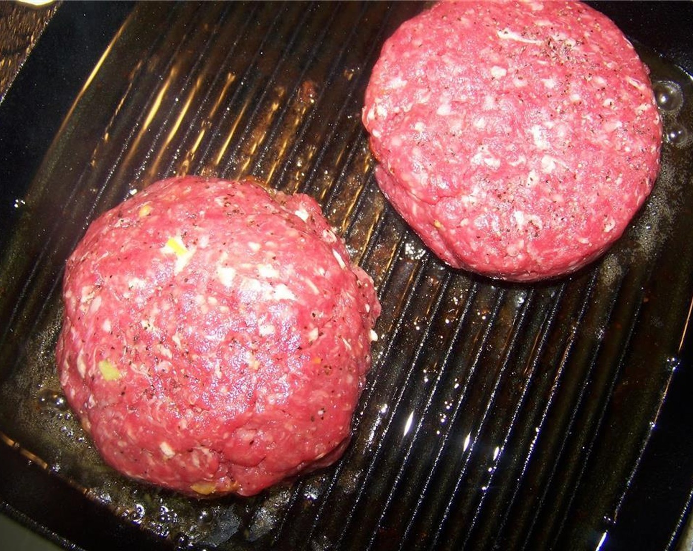 step 9 Heat a cast iron griddle with some canola oil on medium-high heat and grill the patties 5 to 6 minutes per side, until beef is cooked through and the cheese inside has melted.