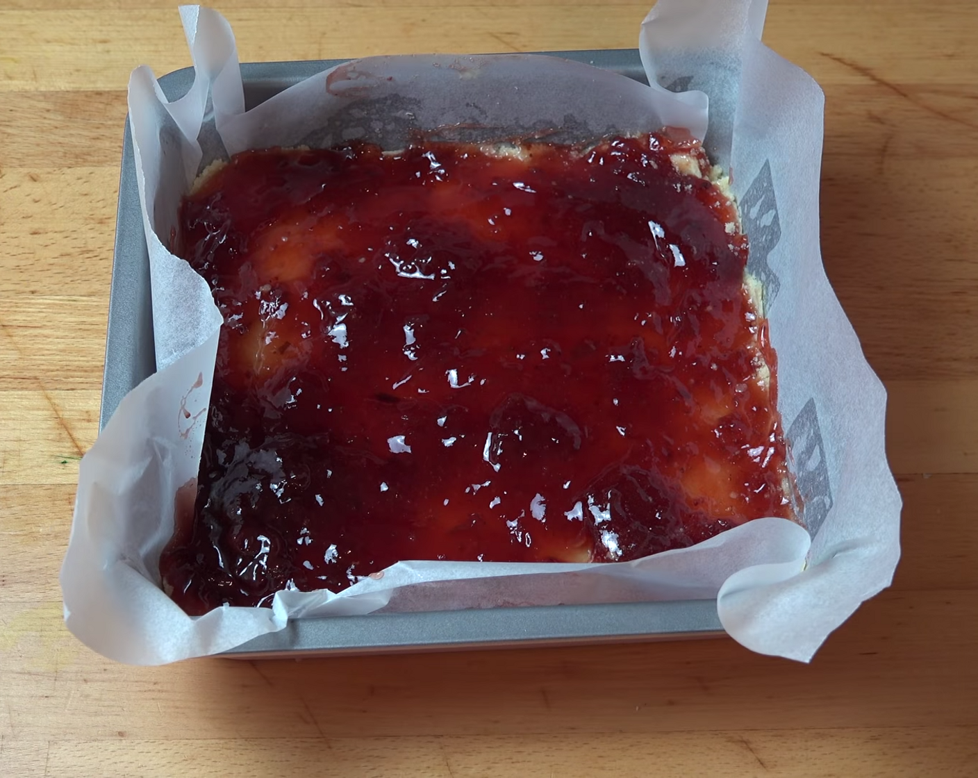 step 8 Top it off with Jam (1 cup). Using the back of a spoon, spread the jam out to all corners of the dough until it's even. Set it aside.