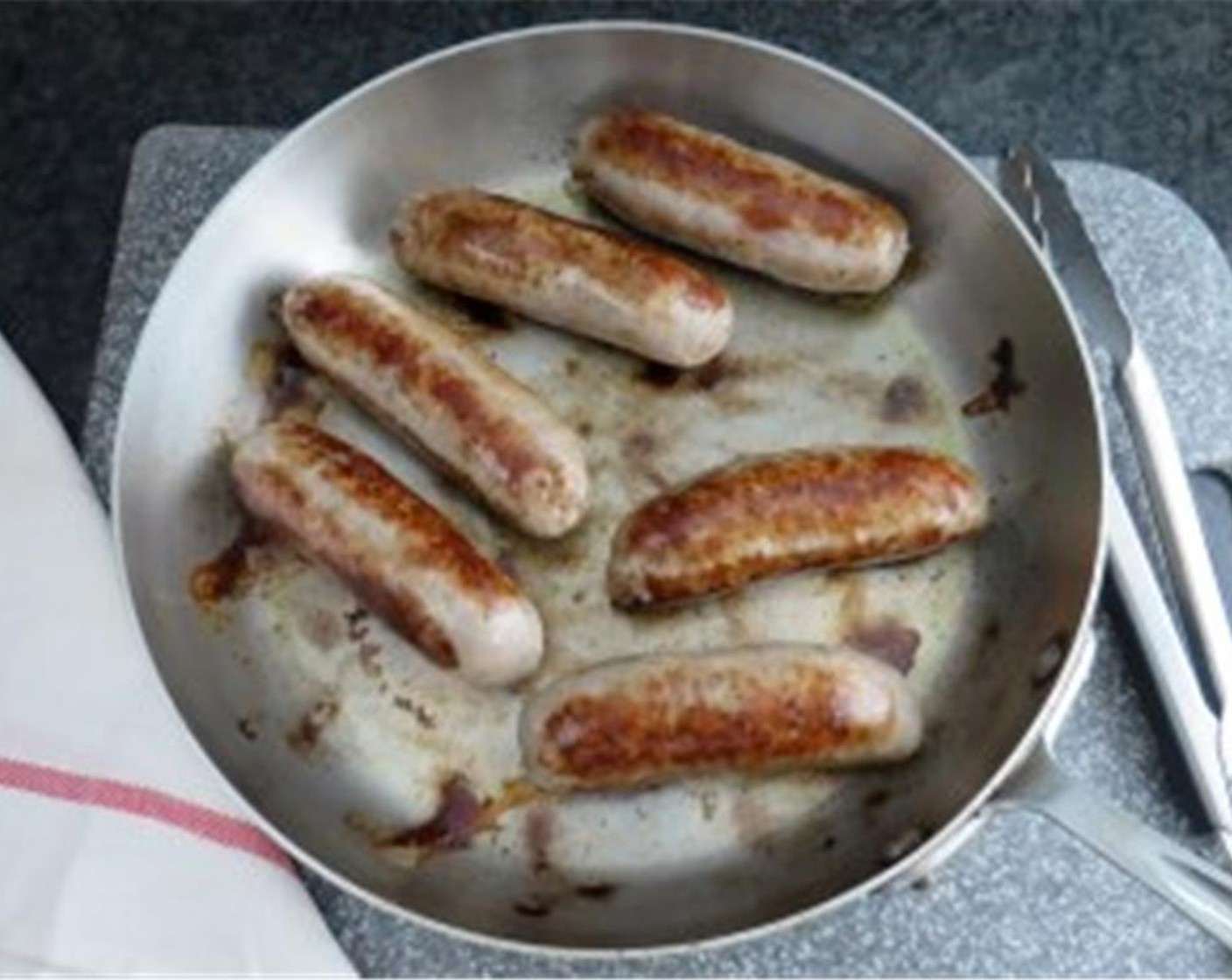 step 5 Meanwhile, in a large skillet, add Olive Oil (1 Tbsp) and heat over medium-high flame. Keep the casings on the Italian Sausage Link (1 lb) and carefully add it to the skillet (they may splatter). Cook for a few minutes on each side until they are browned on several sides.