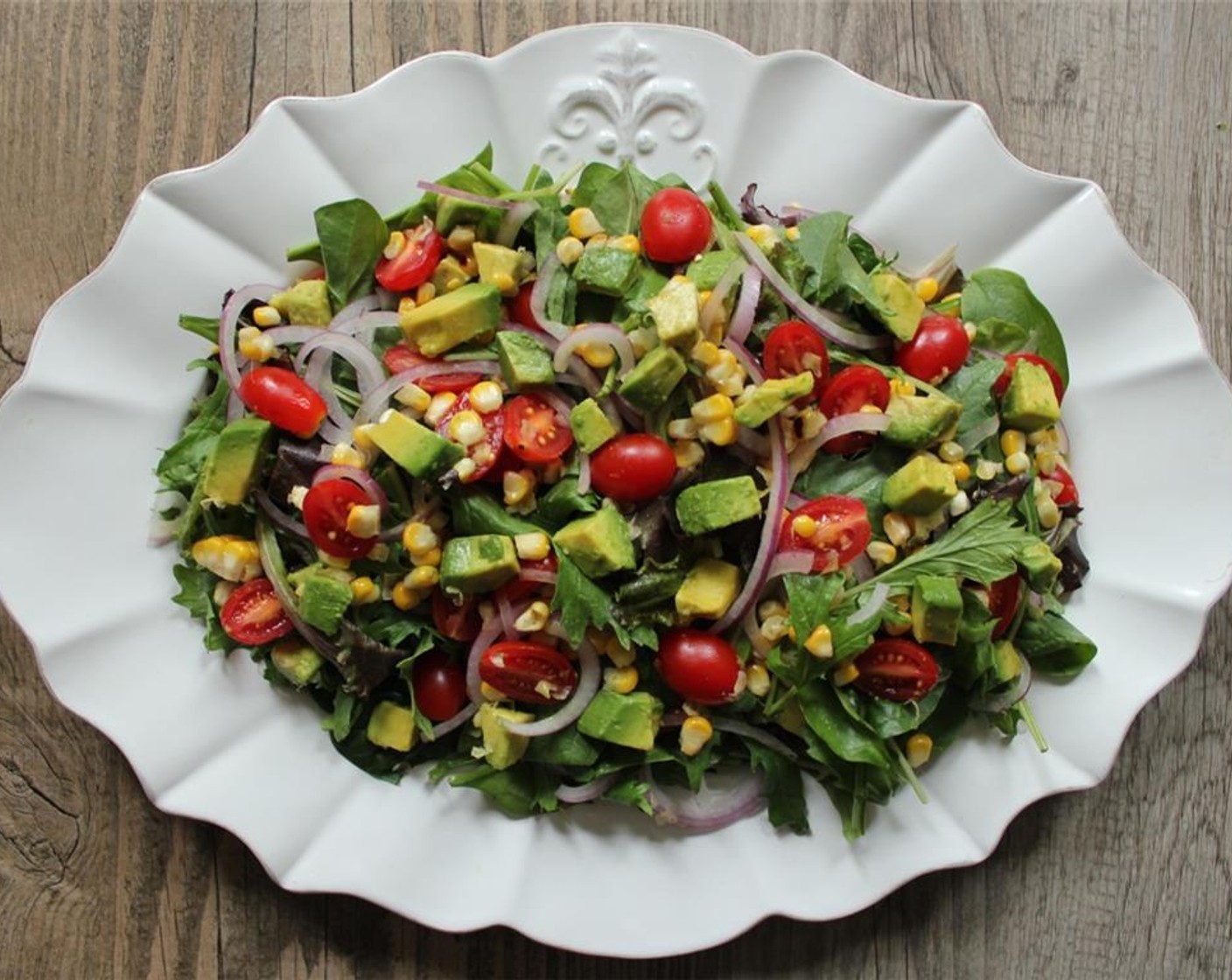 step 9 In a large bowl or on a platter, combine the Spring Mix Greens (4 cups), corn,Red Onion (1/2), Cherry Tomato (1 cup), and Avocado (1).