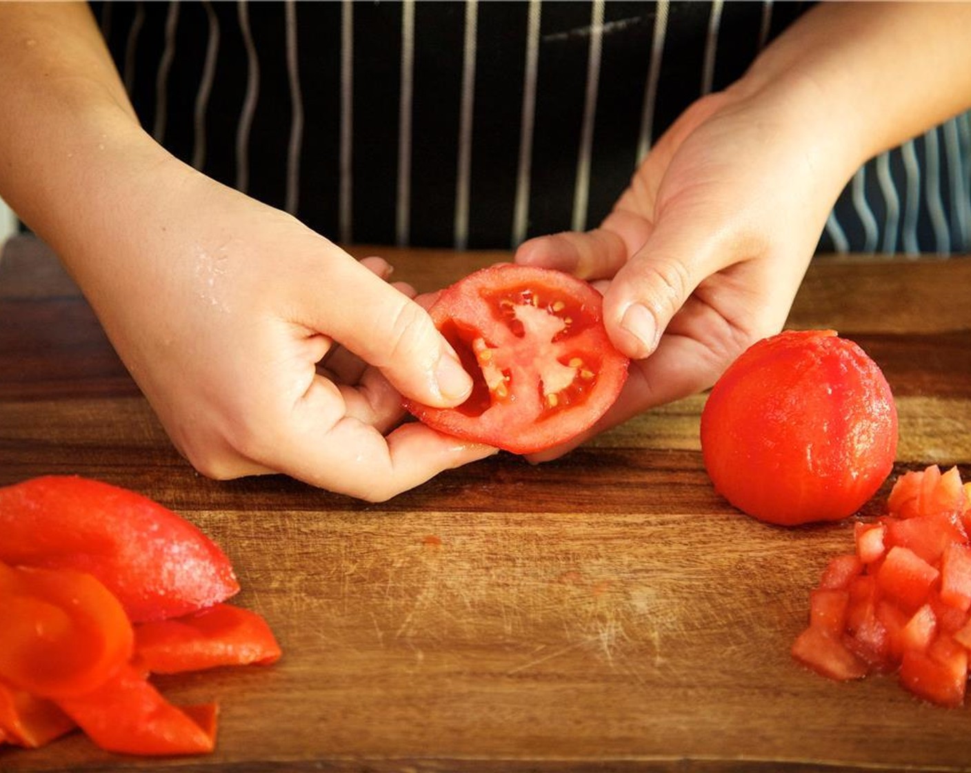 step 10 When the tomatoes have cooled, peel the skin from the tomatoes and discard skins. With the top of each tomato facing upwards, slice each tomato in half across horizontally. Using your fingers, discard the seeds and the interior flesh.