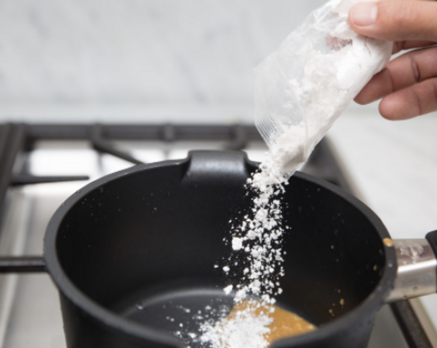 step 11 Transfer all drippings from meatloaves to a small saucepot, and add remaining Cooking Oil (1 tsp). Whisk in flour to thoroughly combine. Place over medium heat, and cook while whisking until the All-Purpose Flour (2 tsp) smells faintly nutty, 1-2 minutes.