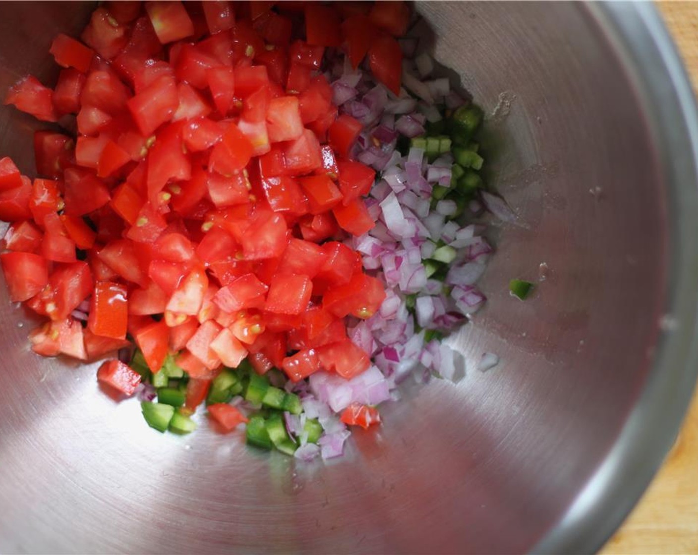 step 3 While the corn roasts, prep the vegetables. Mix the Jalapeño Pepper (1), Red Onion (1/2), Roma Tomato (1), and Red Chili Pepper (1/4 cup). Add the Fresh Cilantro (1/4 cup).