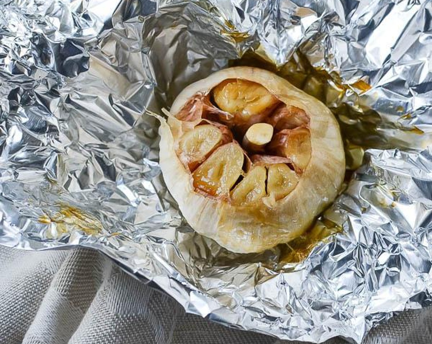 step 3 Drizzle Olive Oil (as needed) over the garlic and wrap it in aluminum foil. Bake for 40-50 minutes until soft. Let cool.