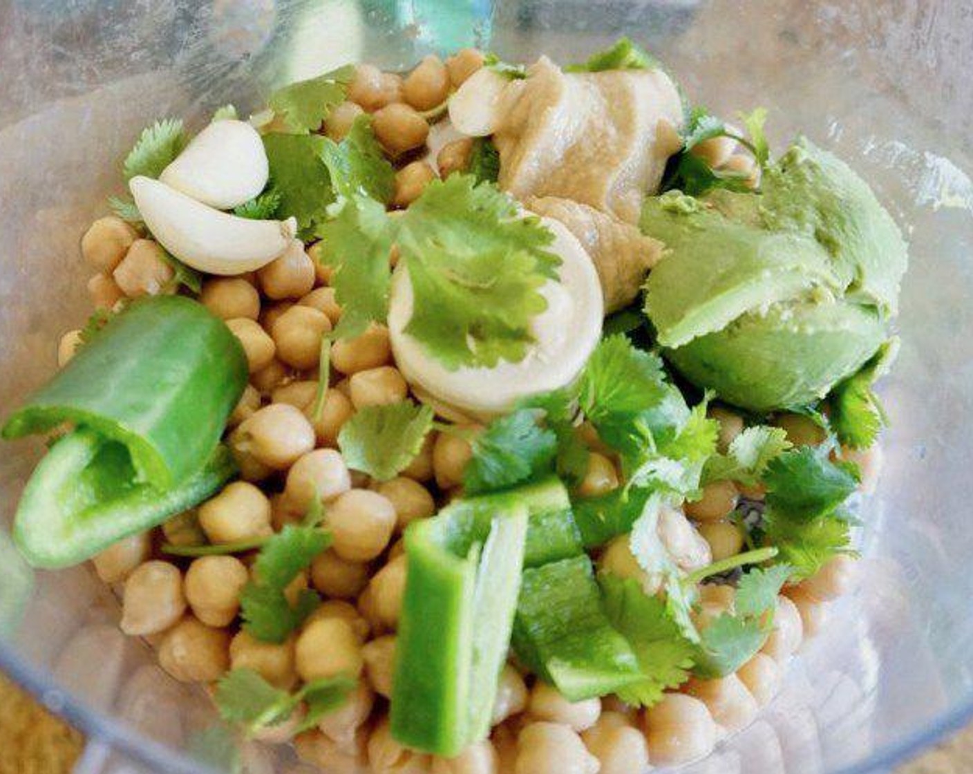 step 1 Add the Chickpeas (1 can), Fresh Cilantro (1/3 cup), Jalapeño Pepper (1), juice of the Lime (1), Garlic (3 cloves), Avocado (1/2) and Tahini (2 Tbsp) to a food processor. Process until the ingredients are fully combined and the mixture just starts to pull away from the sides of the processor.