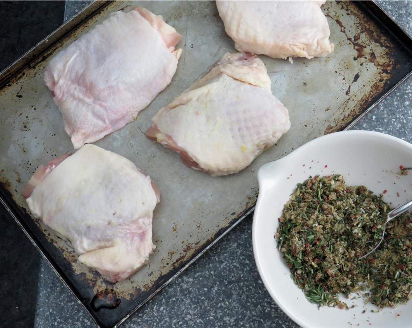 step 2 Using a sharp knife, trim any excess fat from the Bone-in, Skin-on Chicken Thigh (1 lb). Pat chicken dry with a paper towel. Liberally sprinkle the rub onto both sides of the chicken, and press with your fingers so that it adheres.