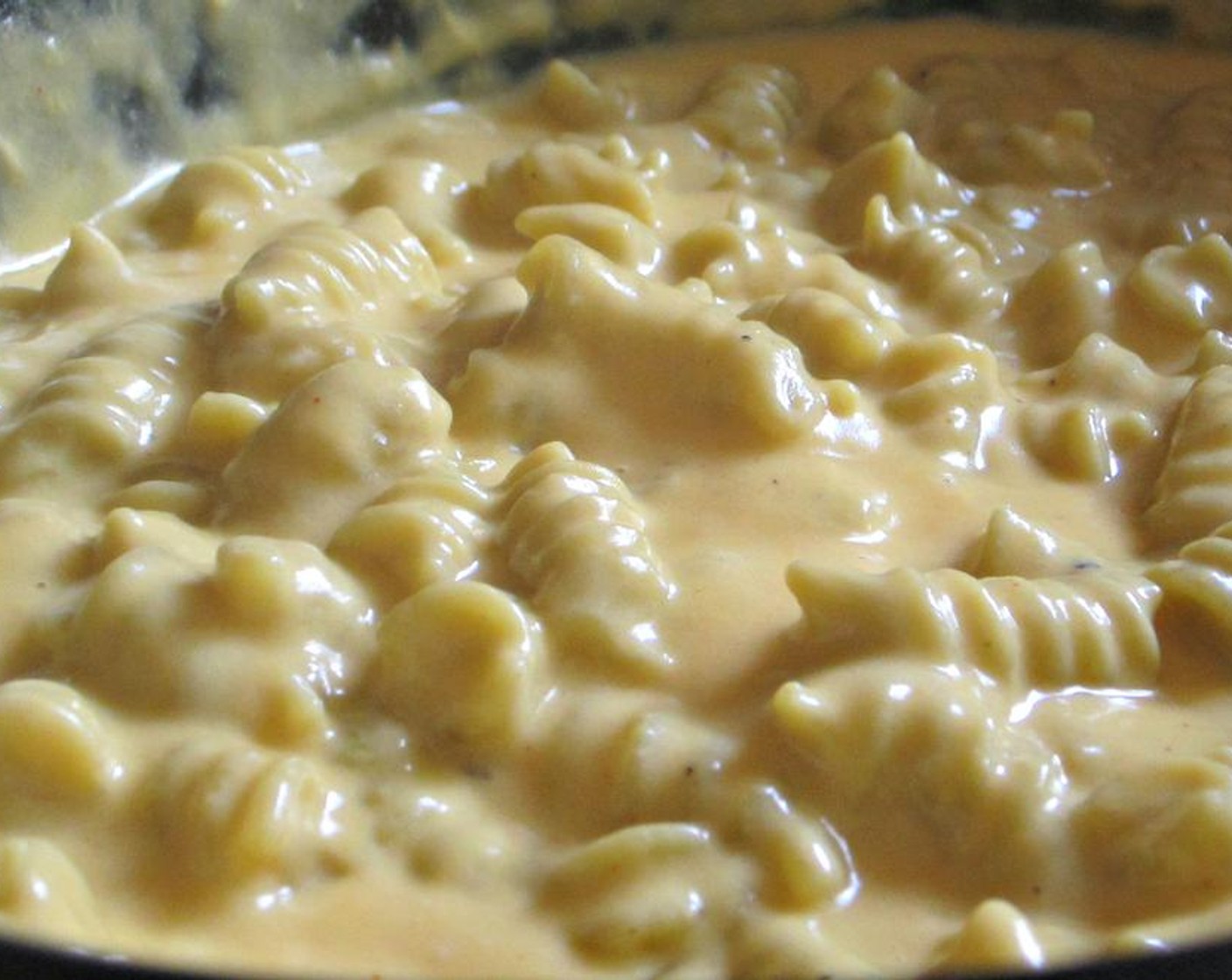 step 2 Slowly add Shredded Reduced-Fat Cheddar Cheese (2 cups) and Shredded Reduced Fat Monterey Jack Cheese (2 cups), until melted and smooth. Add uncooked Vegetable Rotini (4 1/3 cups), to a slow cooker and cover with cheese sauce. Stir well.