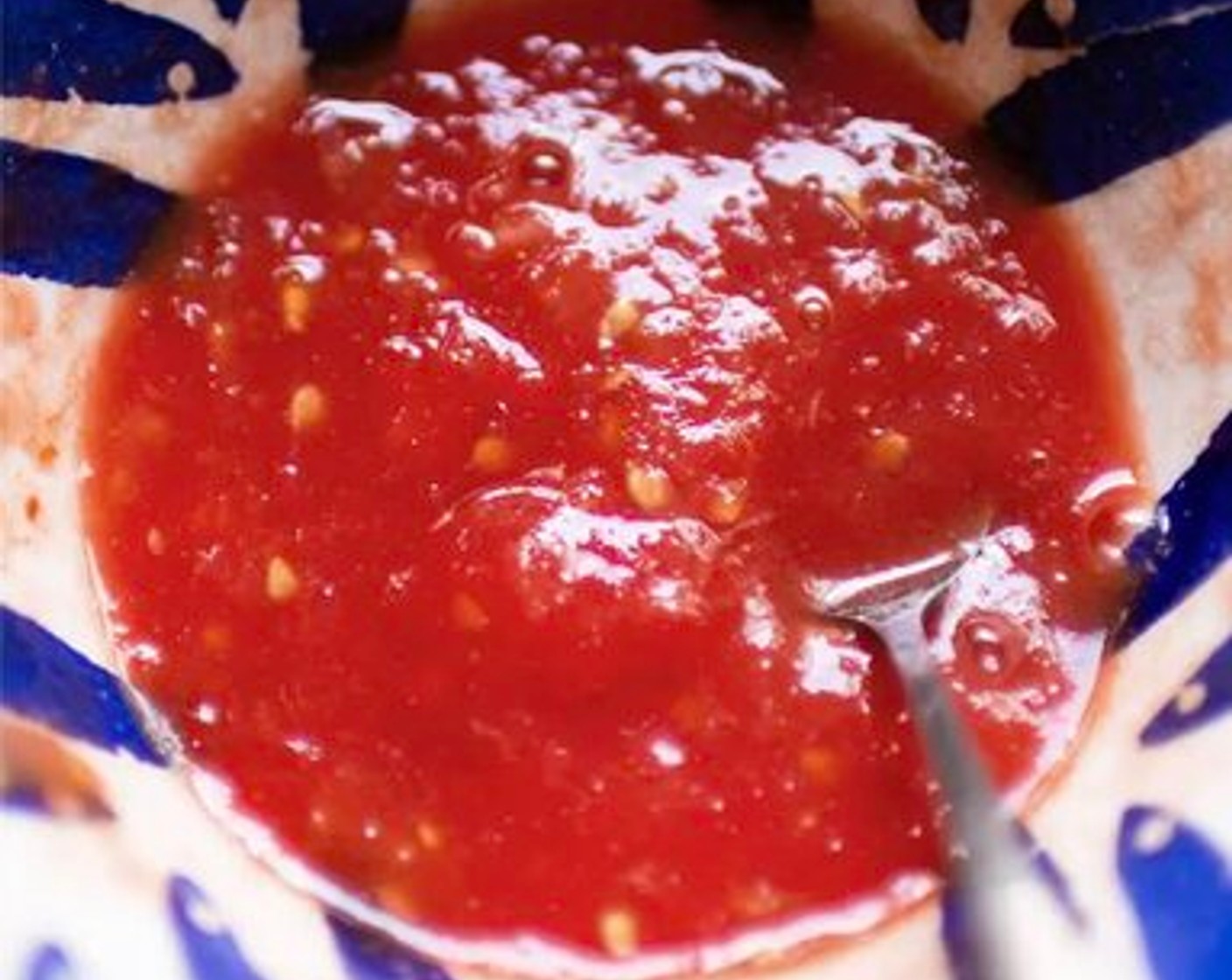 step 2 Over a large bowl, use the largest holes on a grater to grate the Tomato (1). Discard the skin, season with Salt (1 pinch) and set aside.