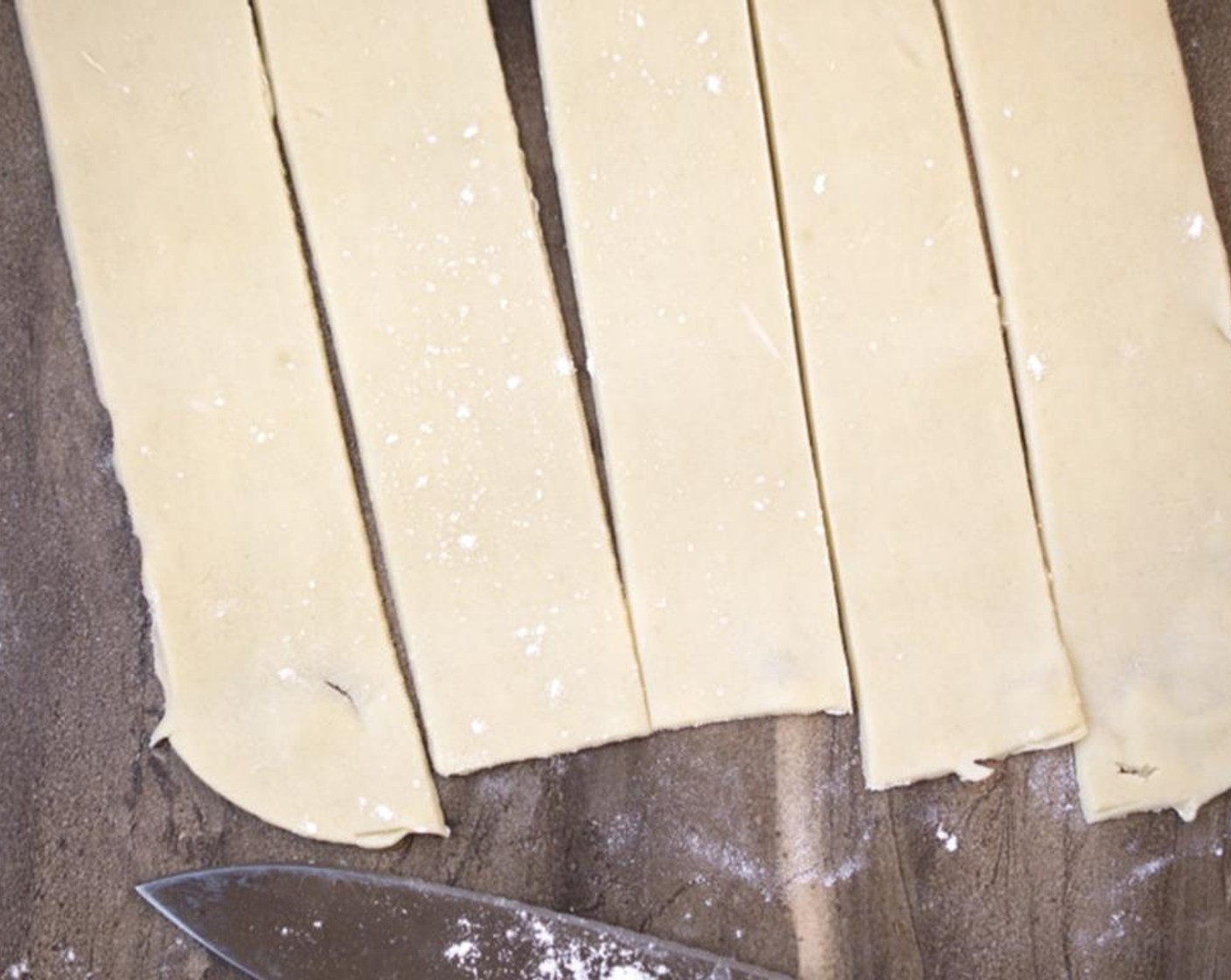 step 3 Start by rolling out the Pie Crust (1 pckg), which should contain 2 crusts, onto a lightly floured surface and cut the rounded edges off so you have a nice long rectangle. Next, cut the dough into long strips.