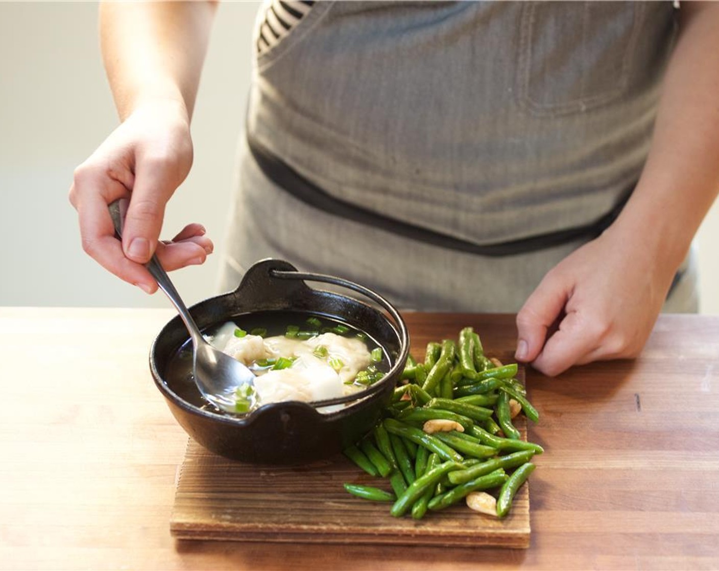 step 12 Ladle the chicken broth in two bowls over the shrimp dumplings. Garnish with remaining sliced green onions. Serve the green beans family style.