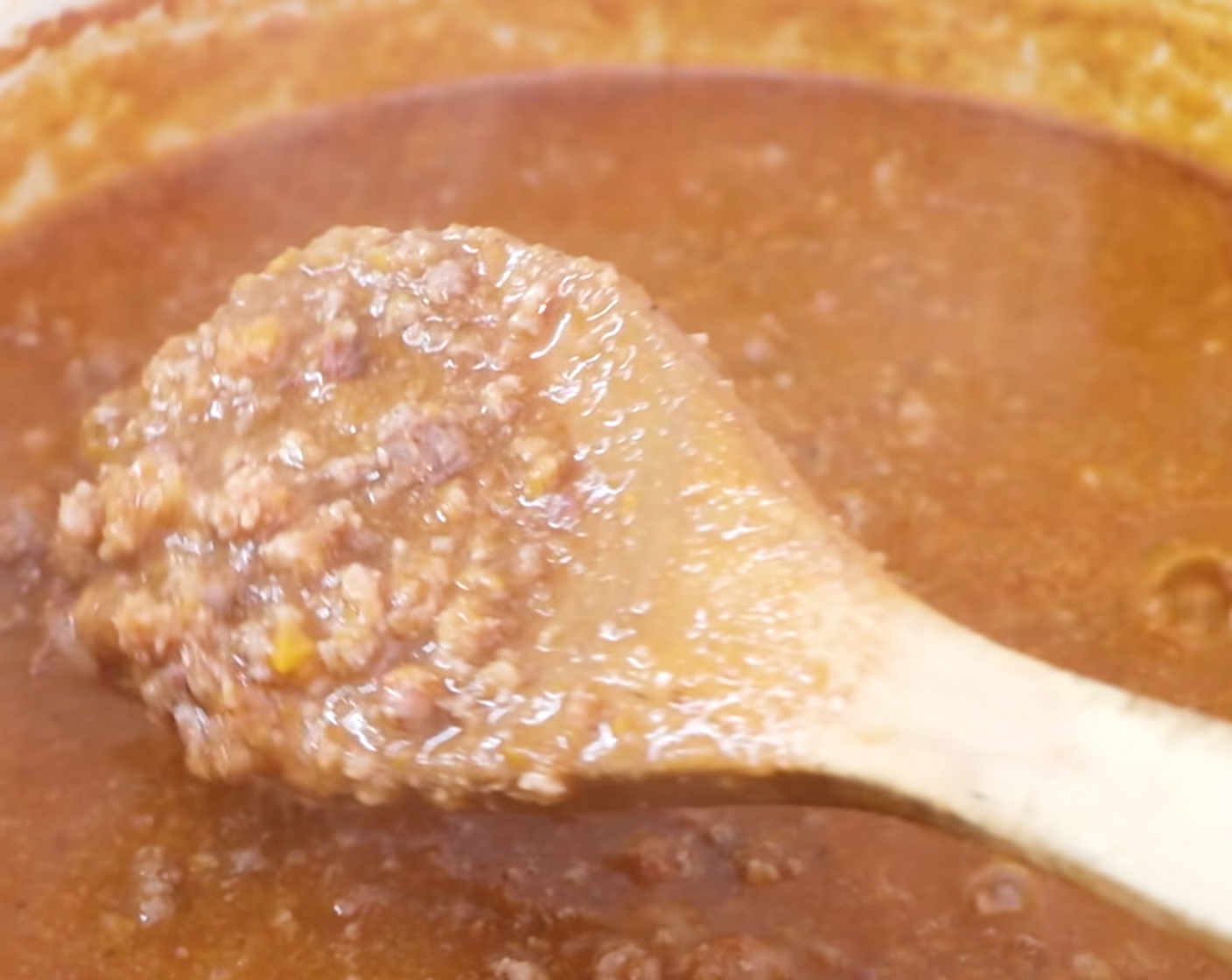 step 10 Once 30 minutes have passed, uncover, and mix well using a wooden spoon. At this point, if there are any thick chunks of meat, break them down again using your wooden spoon before leaving the sauce to simmer once more for 30 minutes, stirring every 10 minutes while leaving the lid off.