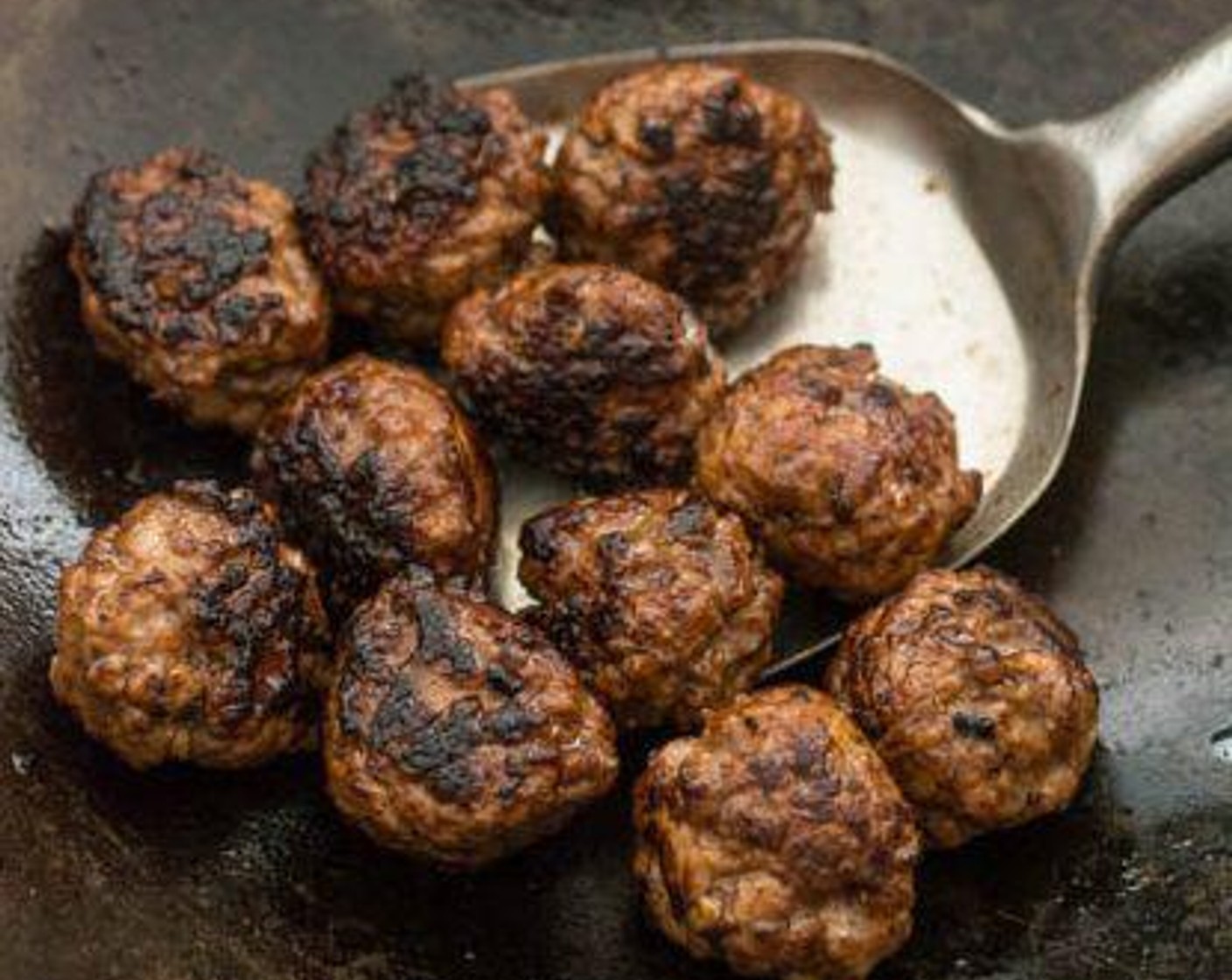 step 5 Use your wok spatula to gently turn the meatballs every so often until fully cooked (about 5 minutes). Continue with the remaining batch of meatballs.