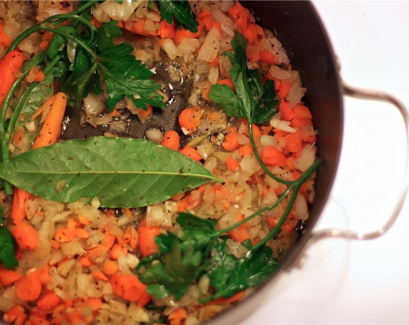 step 5 In the same pot, add the Carrots (2), Onions (1 1/2), and Garlic (3 cloves). Add in Ground Nutmeg (1/2 tsp), Bay Leaves (2), Fresh Parsley (3 sprigs), and Fresh Thyme (1 Tbsp).