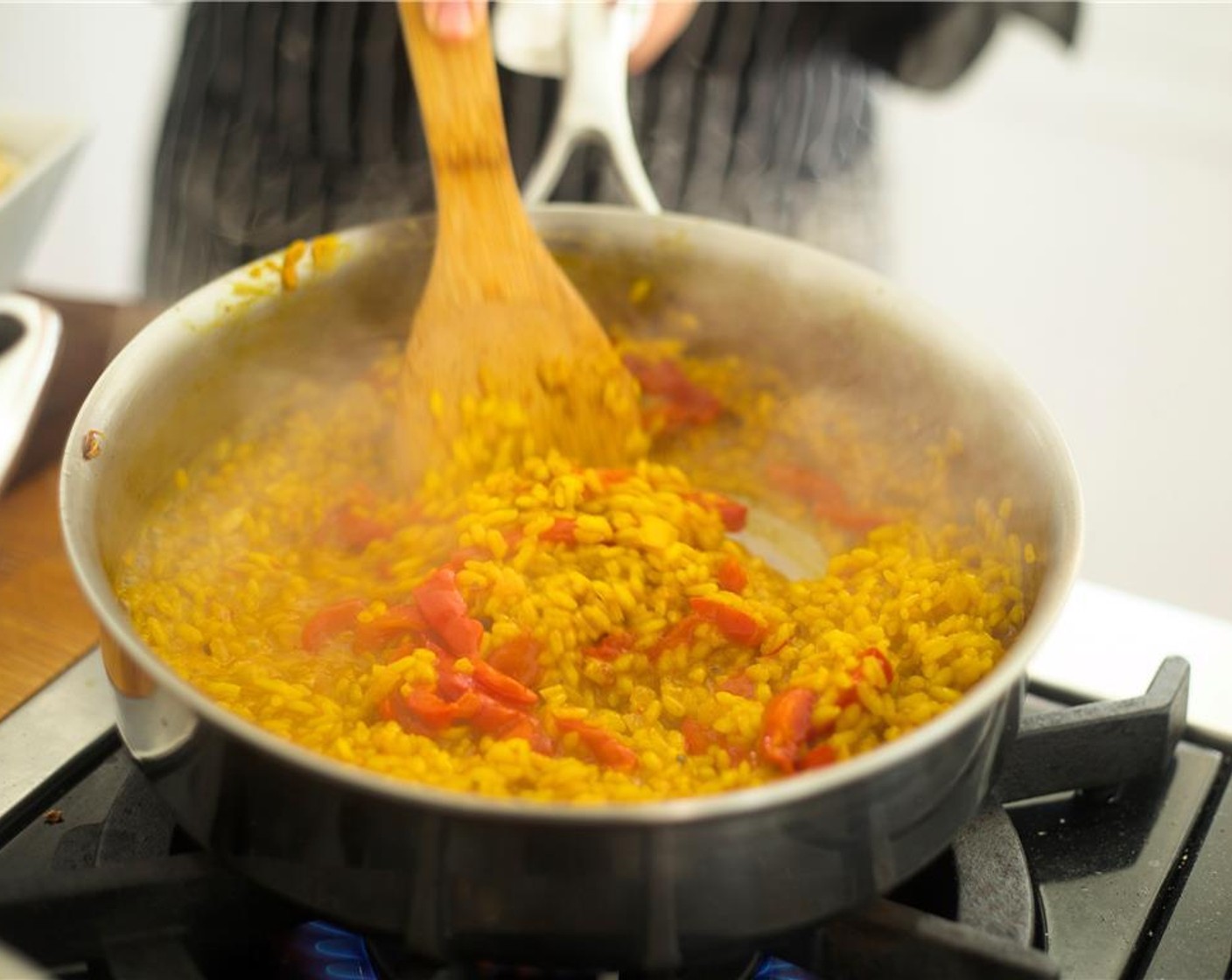 step 12 When rice is finished cooking, remove pan from heat and stir in Butter (1/4 cup), chorizo, Roasted Red Pepper Strips (1/2 cup), and Green Peas (1/2 cup). Season with Salt (1 tsp)