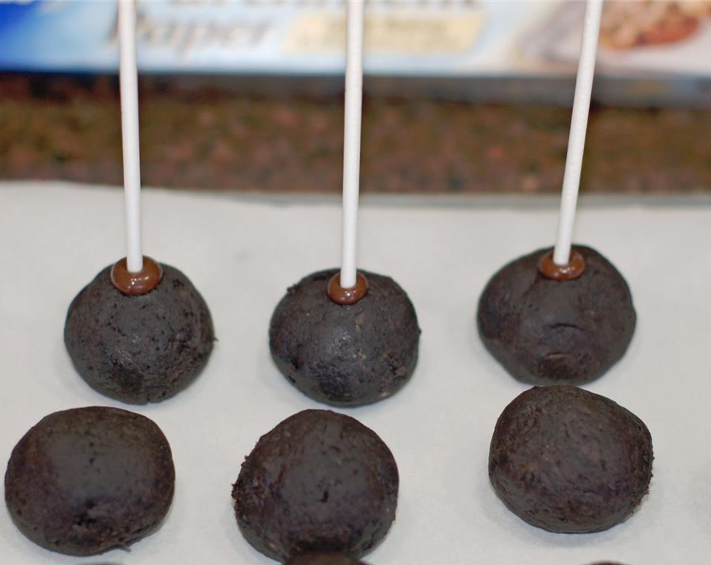 step 5 Remove Oreo balls from the freezer. Dip the tip of each lollipop stick in the candy melt and insert sticks into each ball.