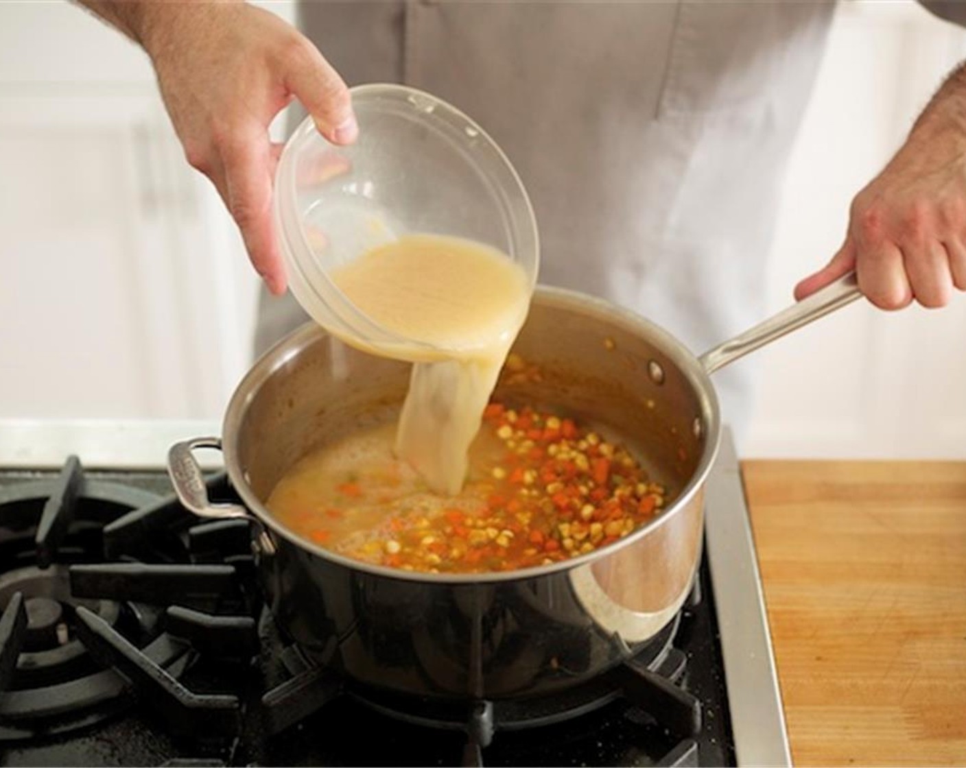 step 8 Add a quarter cup of the chicken broth and scrape the browned bits from the bottom of the pan. Add celery, carrot, corn, and Bay Leaf (1). Stir to coat with broth.