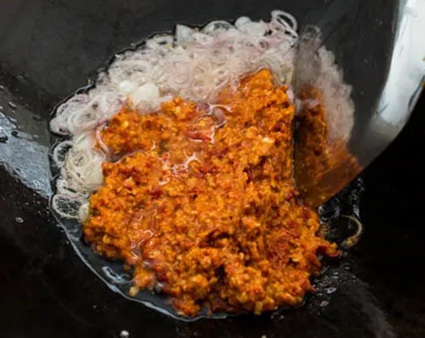 step 8 When the shallots turn slightly brown, pour the sambal paste into the wok. Stir-fry for about 2 minutes.