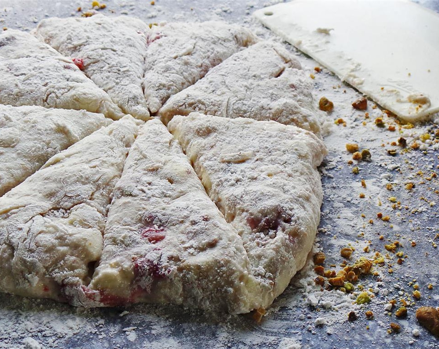 step 9 For traditional triangle scones, lay the dough on a floured surface and press into a rectangle. Cut the dough in half, then in half once more to create four squares. Cut each square in half on a bias to create a triangular scone shape.