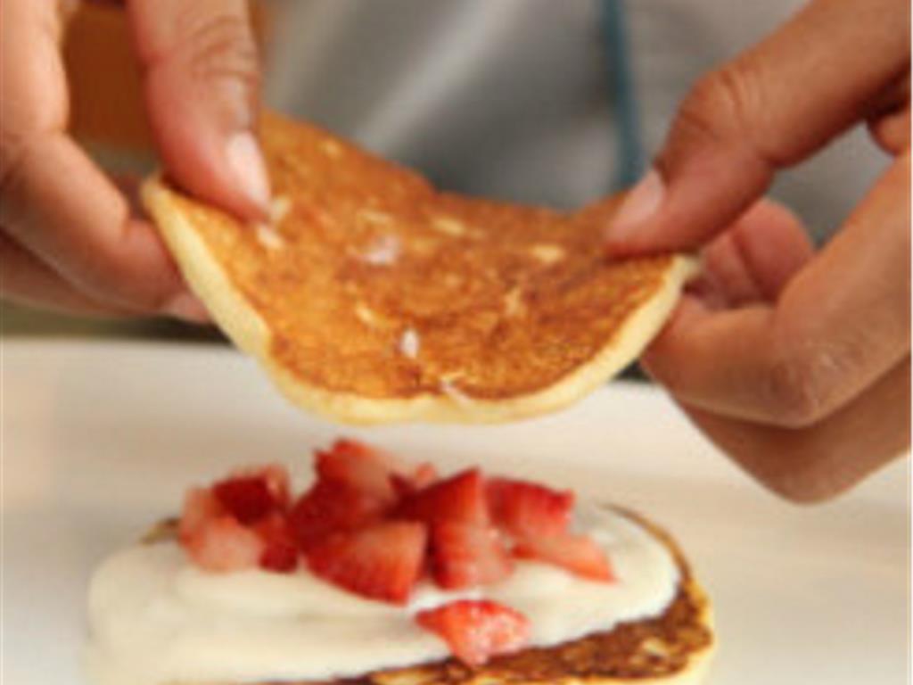 Step 8 of Three Layer Strawberry Pancakes Recipe: Assemble your three-layer strawberry pancakes. Place the pancake on a plate, add whipped cream and then strawberries, and repeat until you have three layers of everything!