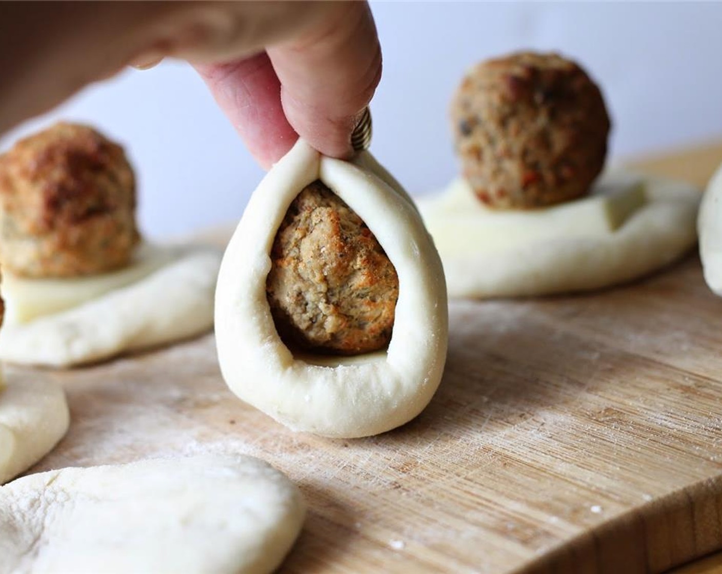 step 3 Stretch dough over meatball and cheese.