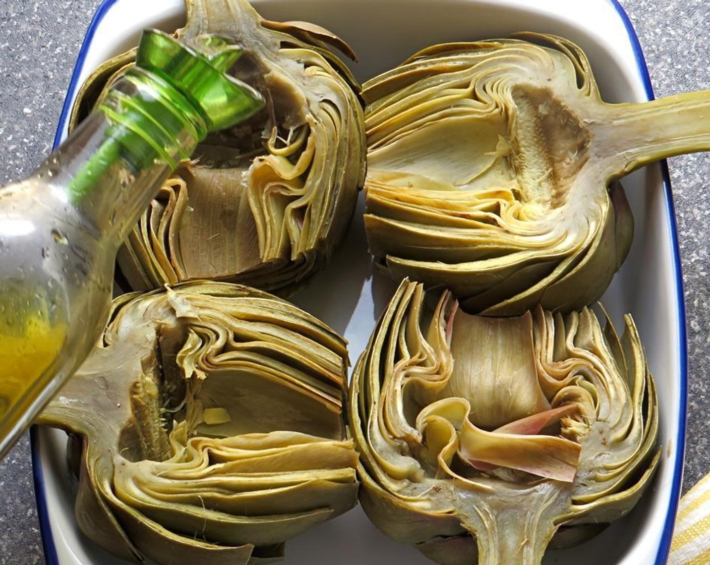 step 8 Spray a baking dish with vegetable spray and lay the artichoke halves, cut side up, in the dish. Drizzle with Olive Oil (1 Tbsp).