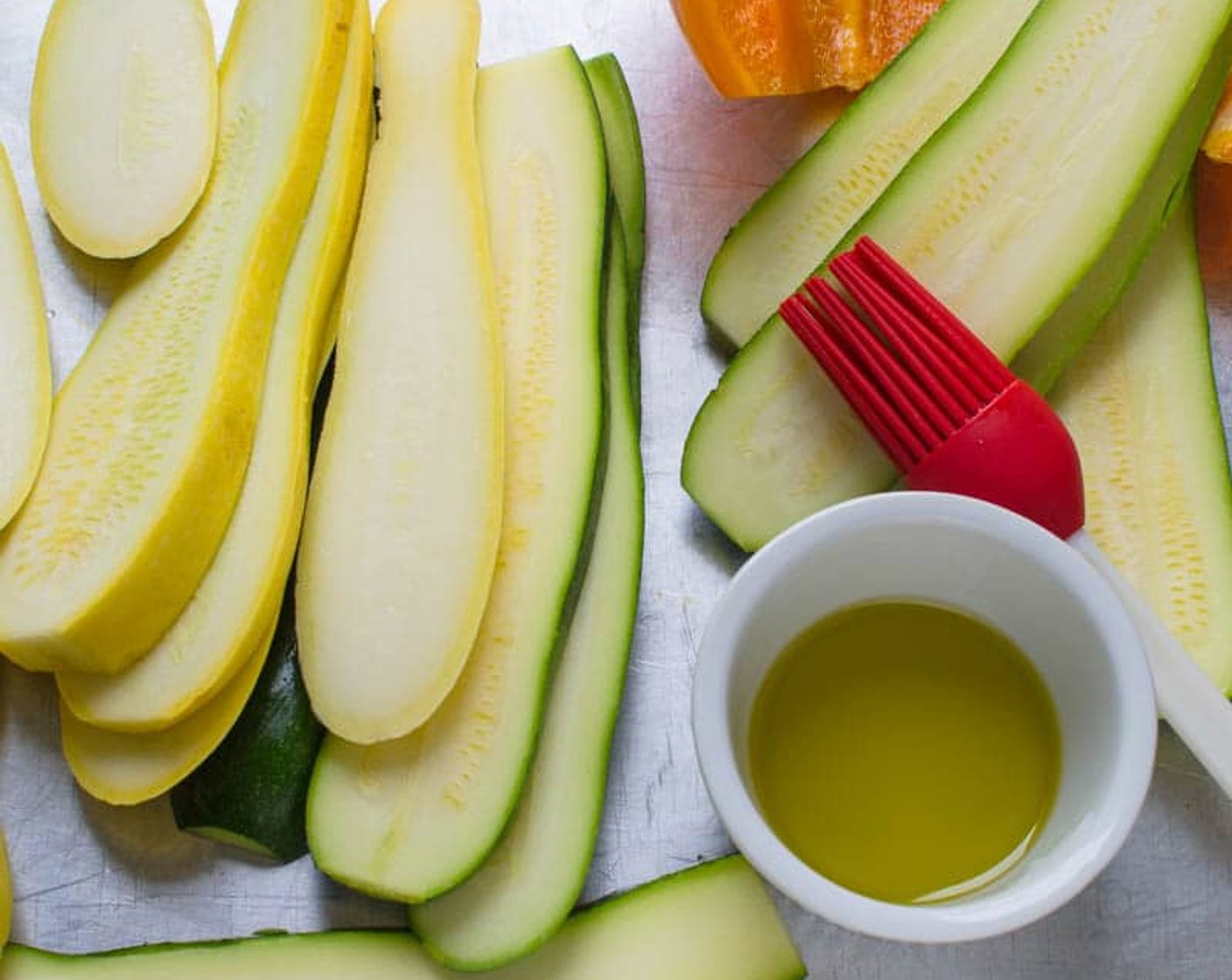 step 4 Brush the Zucchini (2), Yellow Squash (2), bell pepper, and onion with the Olive Oil (2 Tbsp) and sprinkle lightly with Salt (to taste) and Ground Black Pepper (to taste).