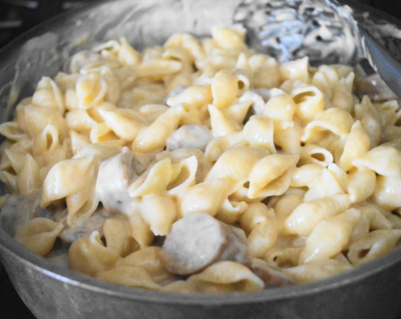 step 9 Drain the pasta shells and add them to the pan with the cheese sauce and bratwurst. Stir it all together well, then take the pan off of the heat.