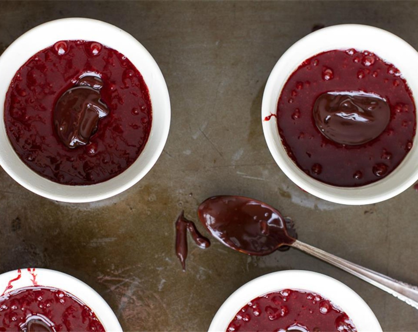 step 7 Divide the mixture among the prepared ramekins. Now grab your ganache from the fridge and spoon about 1-2 heaping teaspoons of ganache right into the center of the ramekins. Use a spoon to scoop the red velvet mixture over the ganache.