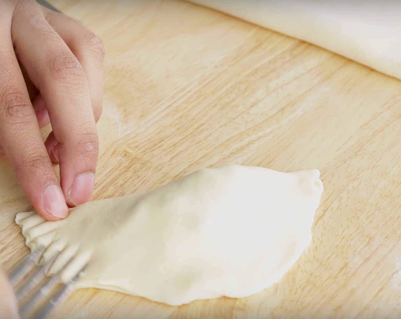 step 8 To assemble the empanadas, place a spoonful of the chicken filling on the middle of each empanada disc. Add a sprinkle of Mozzarella Cheese (to taste) if you want. Fold the disc and seal the edges by pressing the dough with a fork dipped in flour.