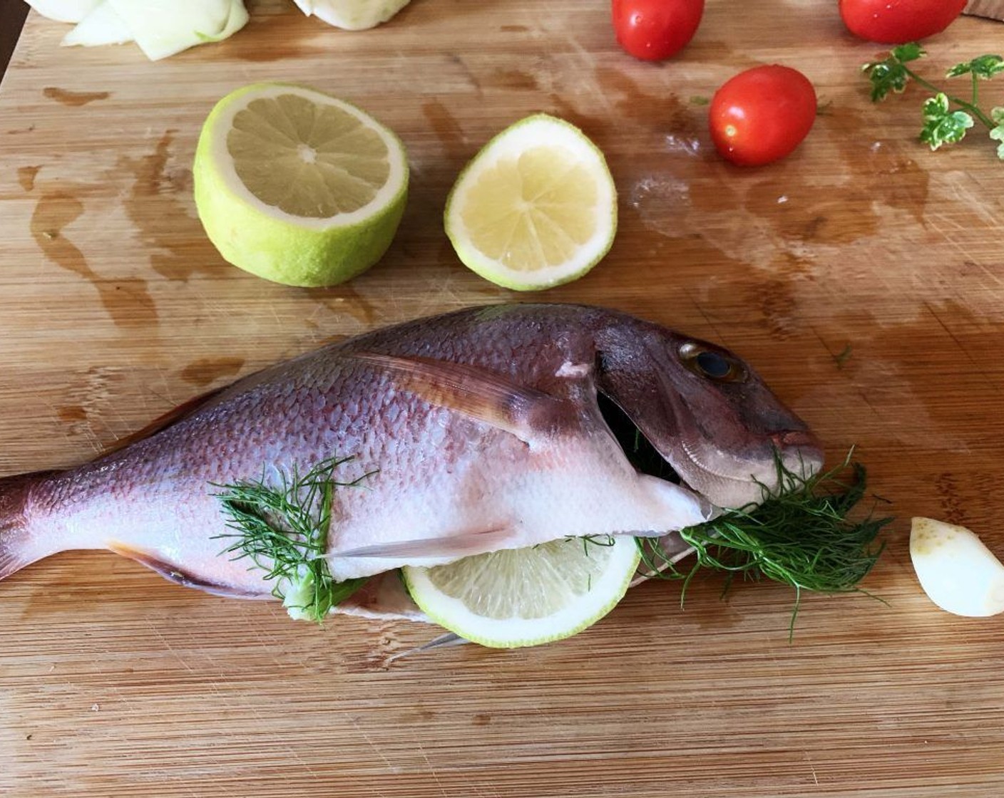 step 1 Wash the Whole Sea Breams (1.1 lb), season the inside with Salt (to taste) and Ground Black Pepper (to taste), and stuff it with some Fresh Parsley (to taste) leaves, a few slices of Lemon (1/2) and Garlic (1/2 clove).