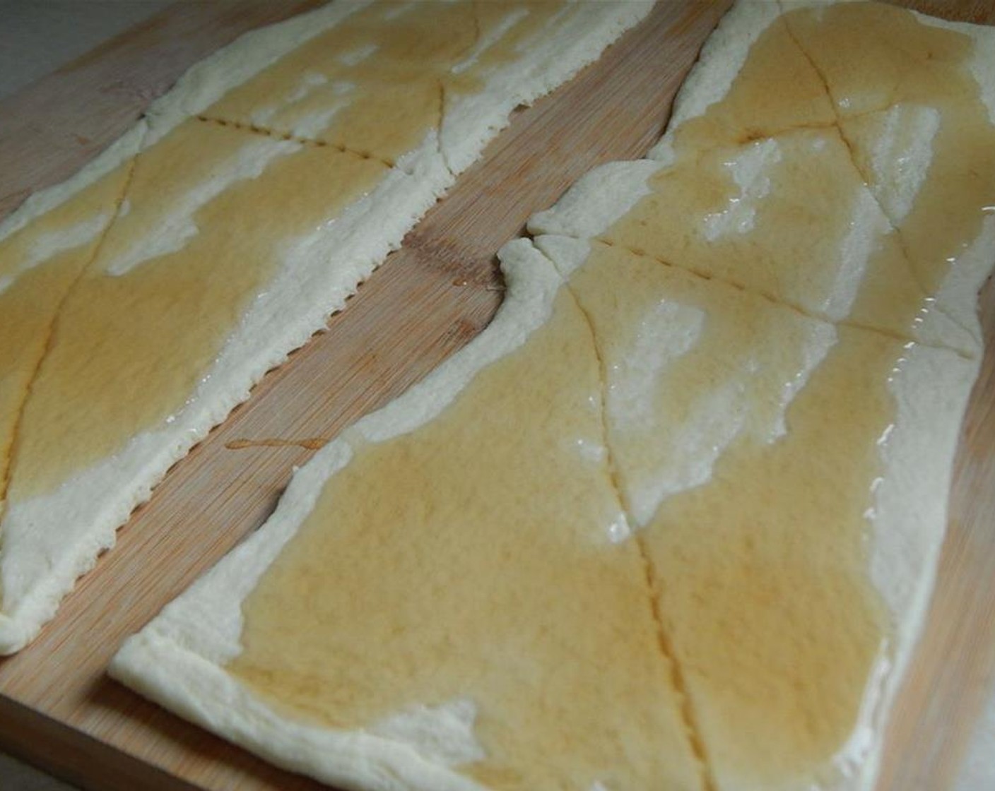 step 3 Lay out Pillsbury™ Reduced Fat Crescent Rolls (1 pckg) into two strips of four. Seal where the cuts are. Pour Light Maple Syrup (4 Tbsp) onto each piece.