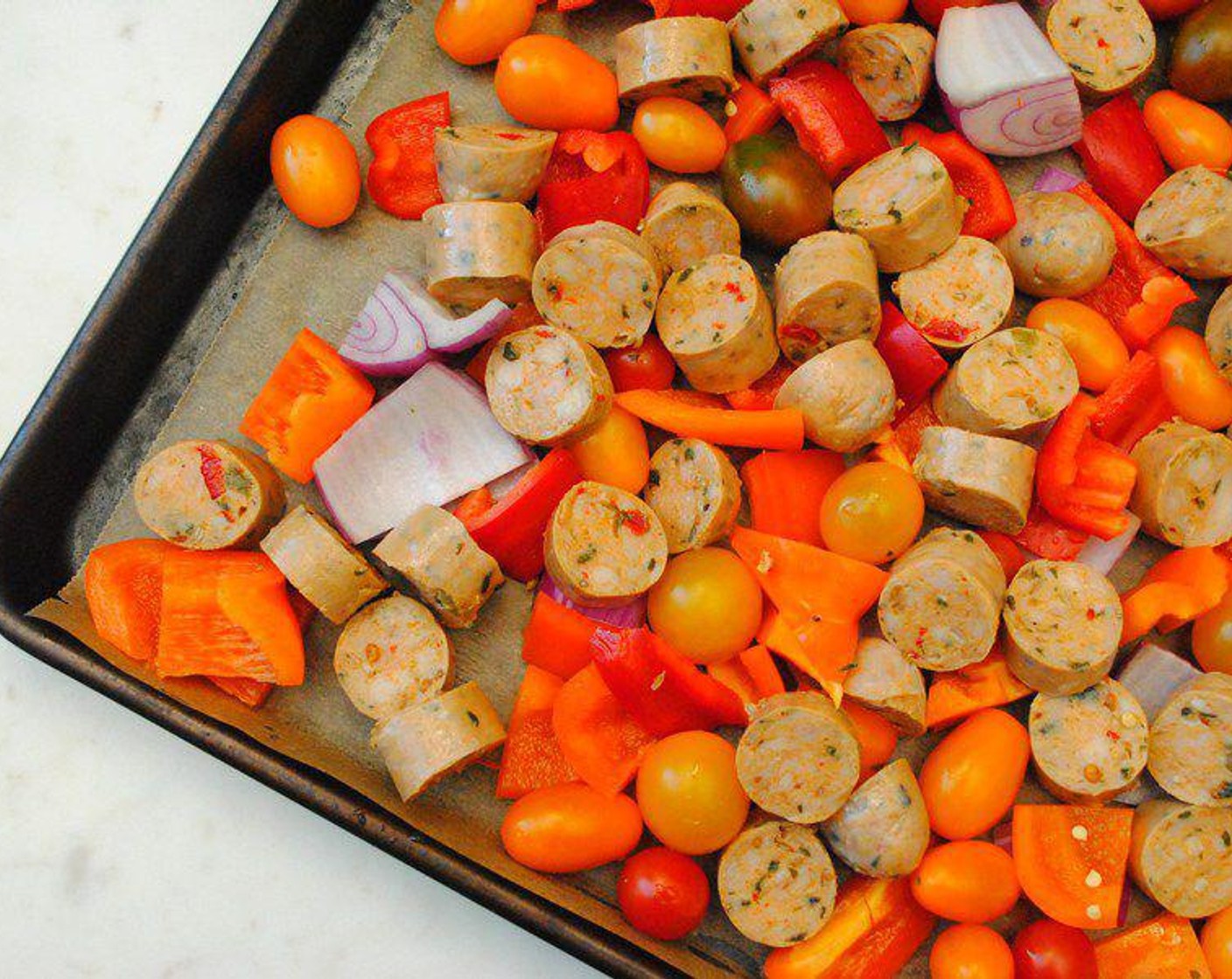 step 2 On the sheet pan, mix the Hot Italian Chicken Sausage Link (1 lb), and Bell Peppers (2), Red Onions (2), and Cherry Tomatoes (2 cups) with Olive Oil (2 Tbsp), Salt (1 tsp), and Ground Black Pepper (1/2 tsp).