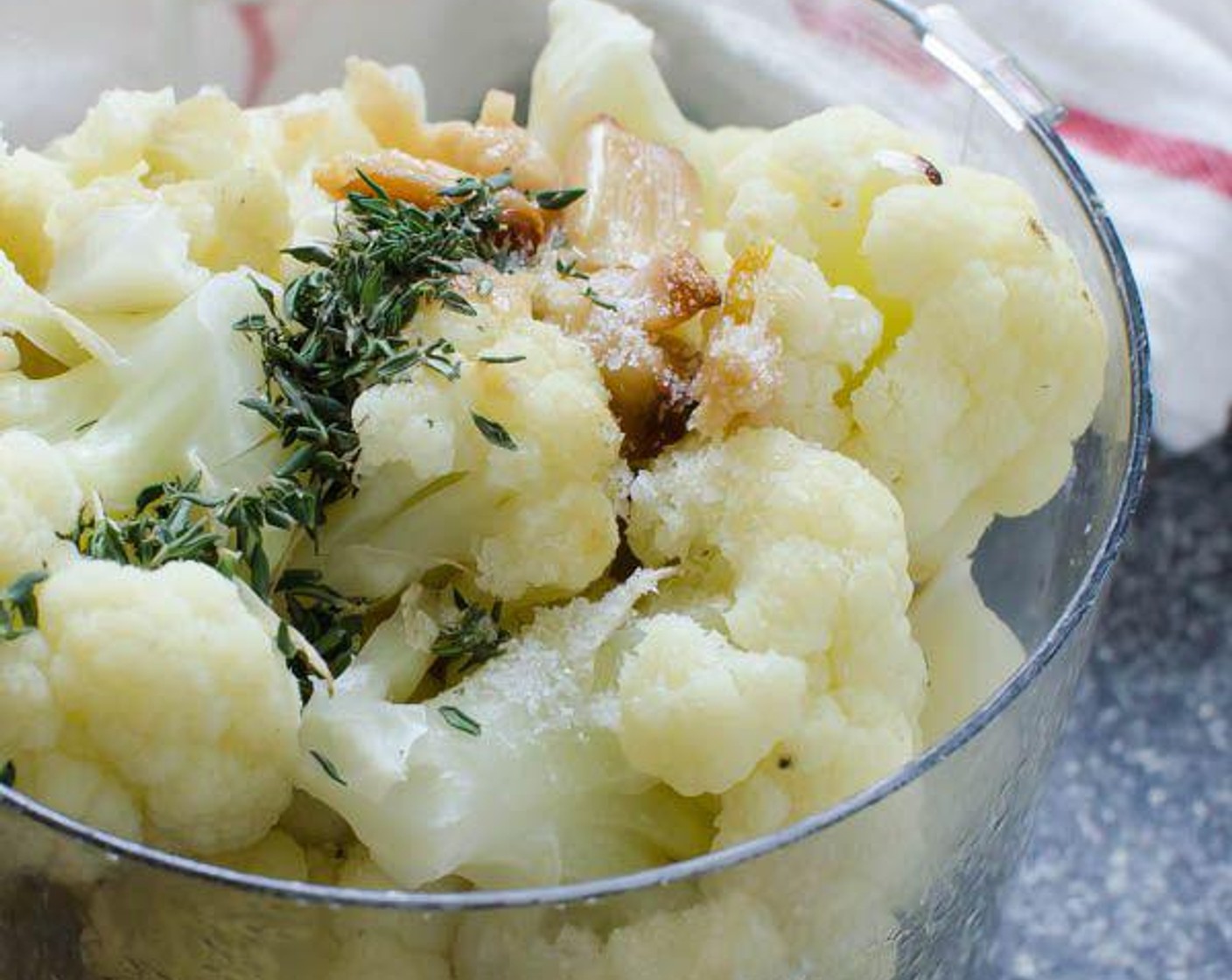 step 5 Transfer cauliflower to a food processor. Squeeze the individual cloves of roasted garlic into the cauliflower. Add the Fresh Thyme (1/2 Tbsp) and secure the lid on the food processor.