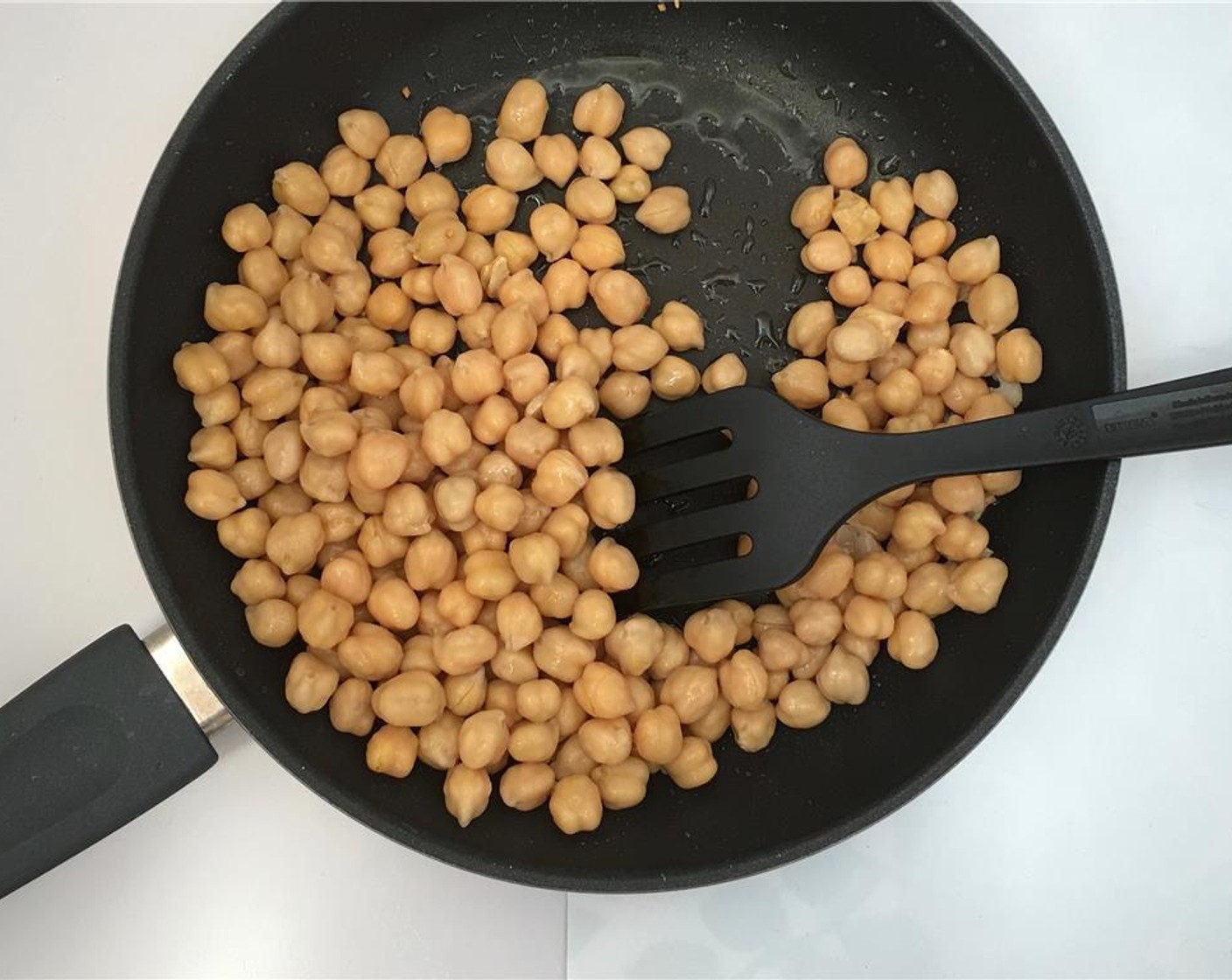 step 2 Place the pan over medium heat and let the garlic gently fry for 4 minutes. Then add Canned Chickpeas (1 cup).