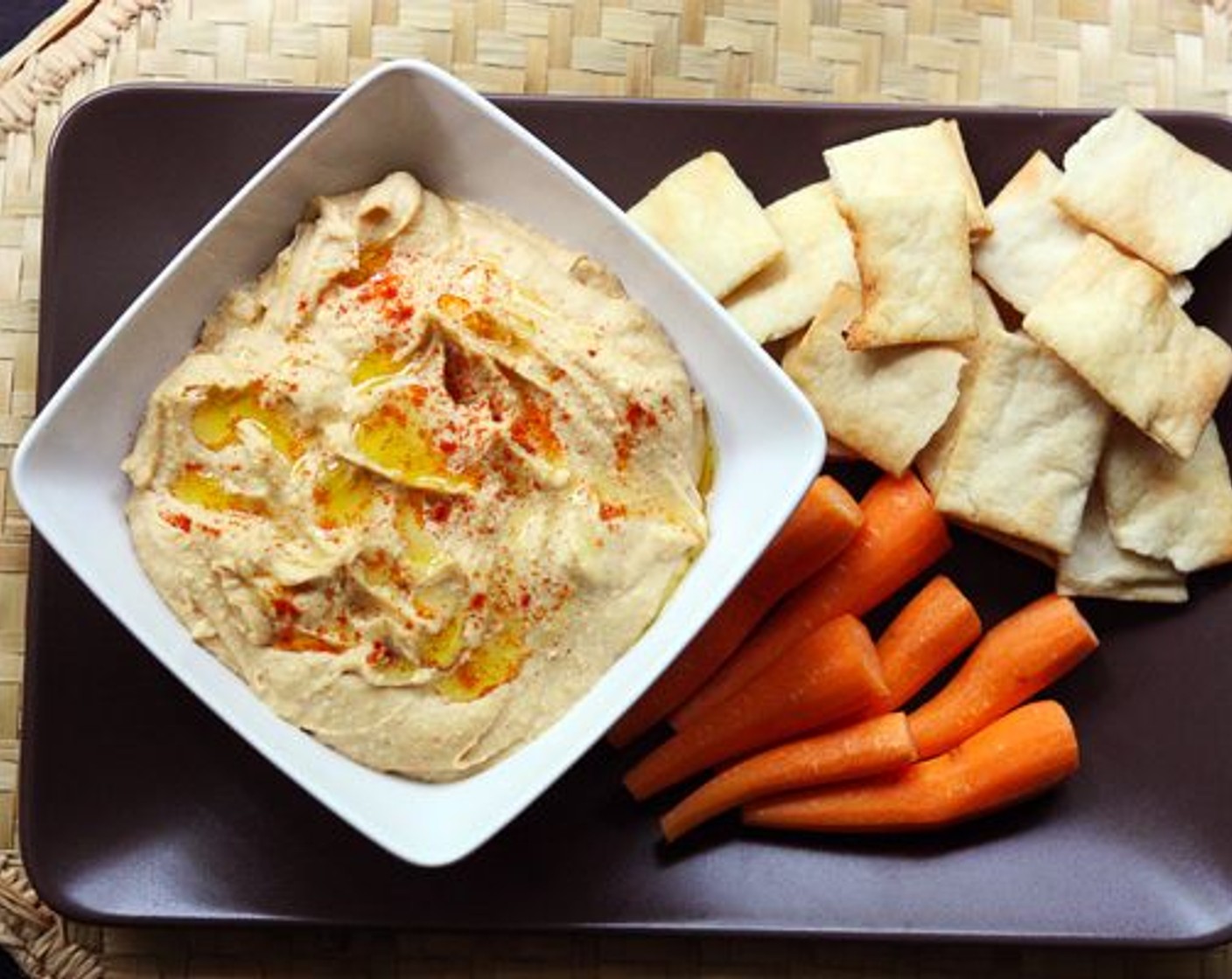 step 4 Spoon hummus into a serving bowl and drizzle lightly with Olive Oil (to taste) and sprinkle with a bit more paprika. Serve with pita chips or pita and carrots.