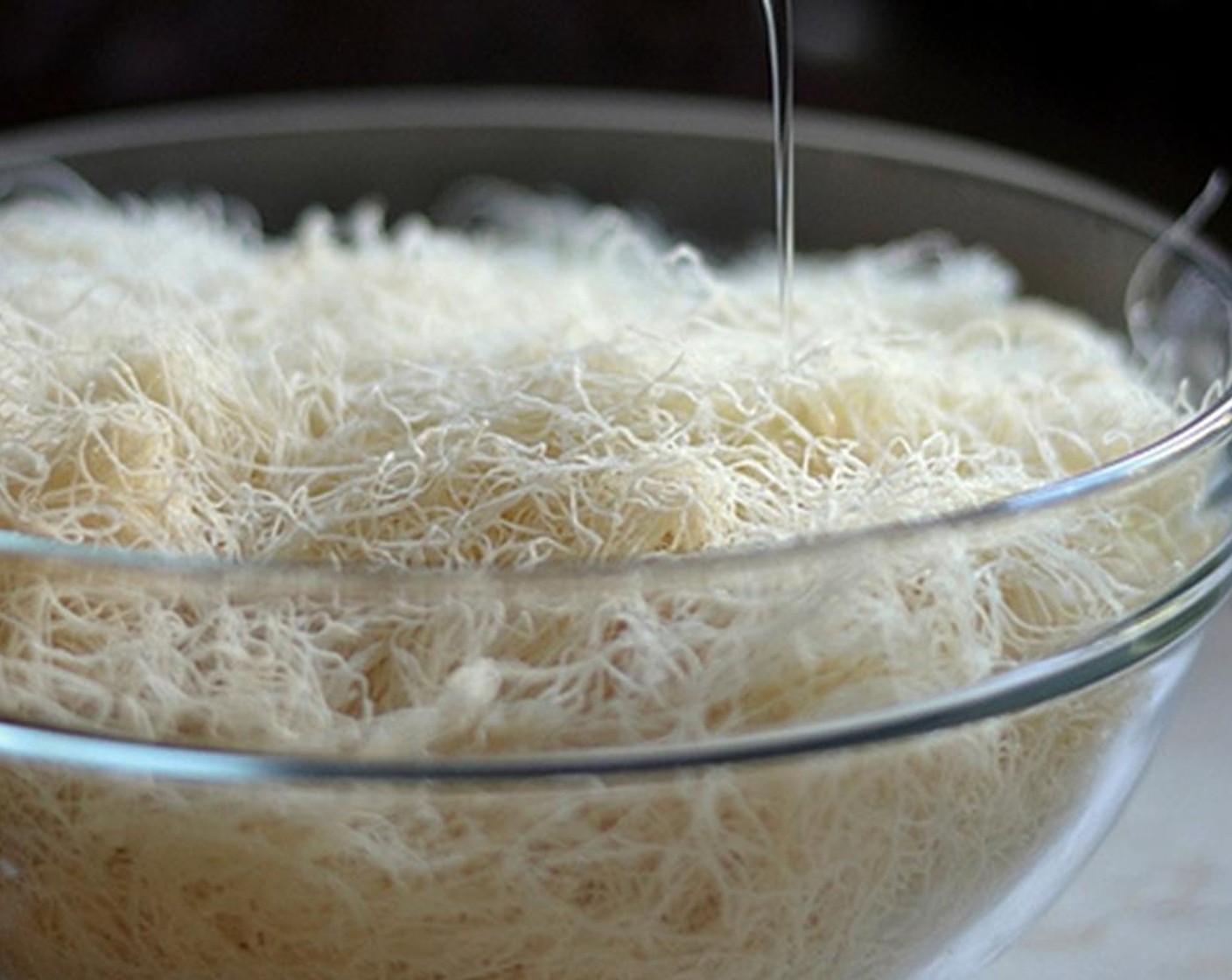 step 5 Add Corn Oil (1 cup) to the Kunafa (1 3/4 cups) and then use your fingers to fluff it. Cut the long strands into shorter pieces.