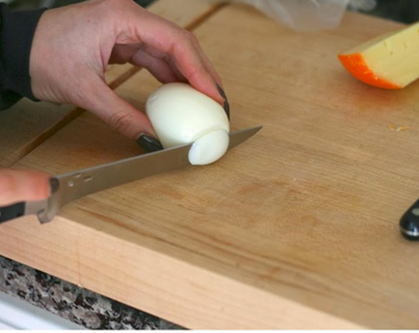 step 8 Trim a little off each end of a peeled egg so that it creates a level surface. Cut the egg in half across the middle and remove and place the yolks in a bowl and the whites on a tray.