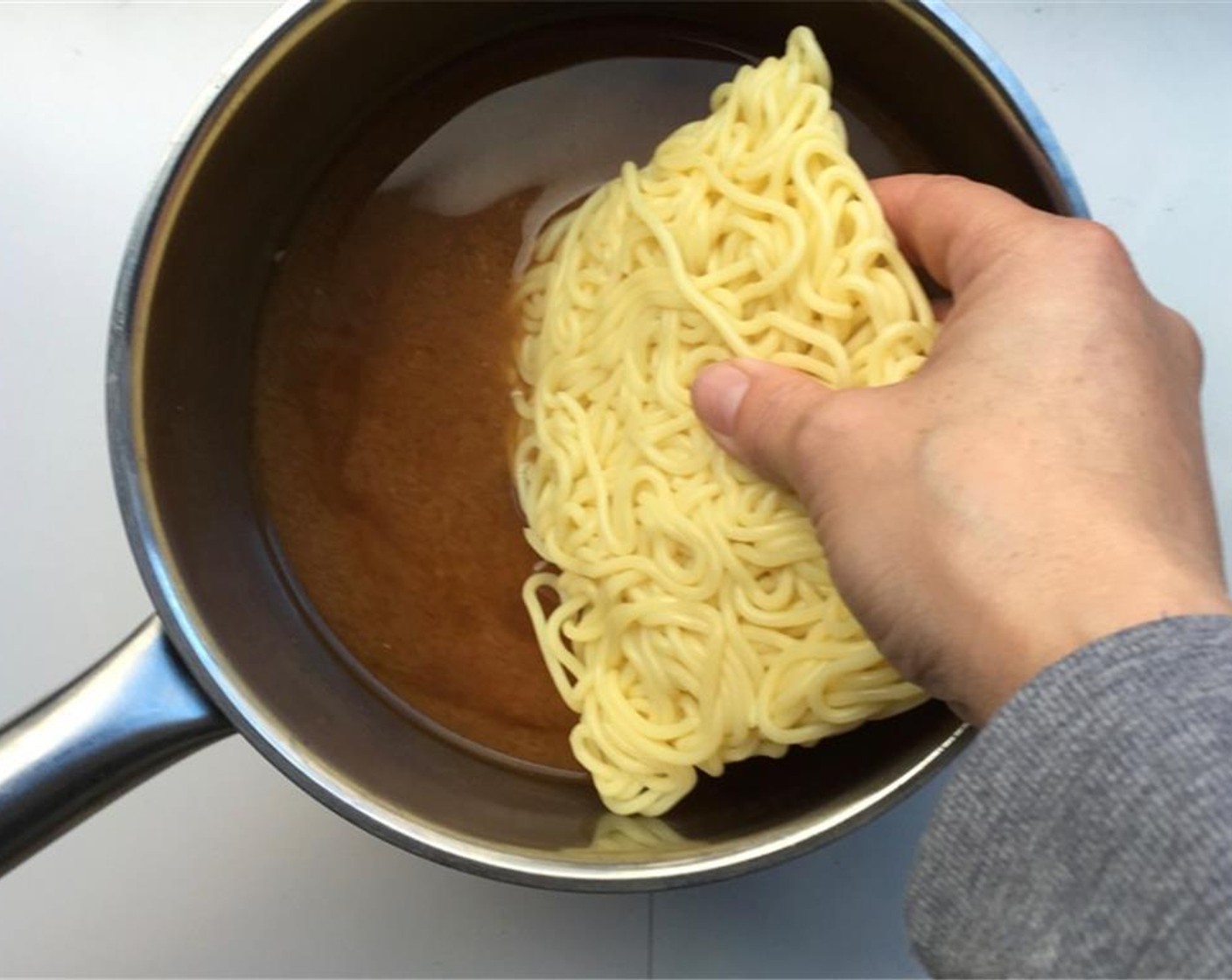 step 5 Give it a good stir and bring it to a gentle boil. Once the red miso paste has dissolved, add the Udon Noodles (5.5 oz).