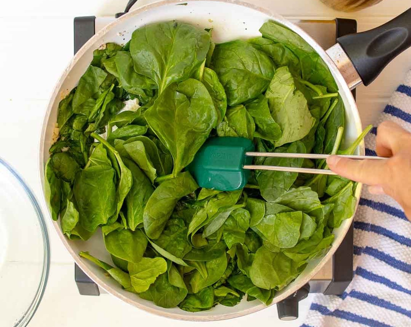 step 2 In a large nonstick skillet heat Olive Oil (1/2 Tbsp) over medium heat. Add Garlic (3 cloves) and saute for 1 minute. Add half of Fresh Baby Spinach (7 1/2 cups), Salt (1/4 tsp) and Ground Black Pepper (1/4 tsp). Stir until spinach is wilted. Continue to add handfuls of spinach until all spinach is wilted.