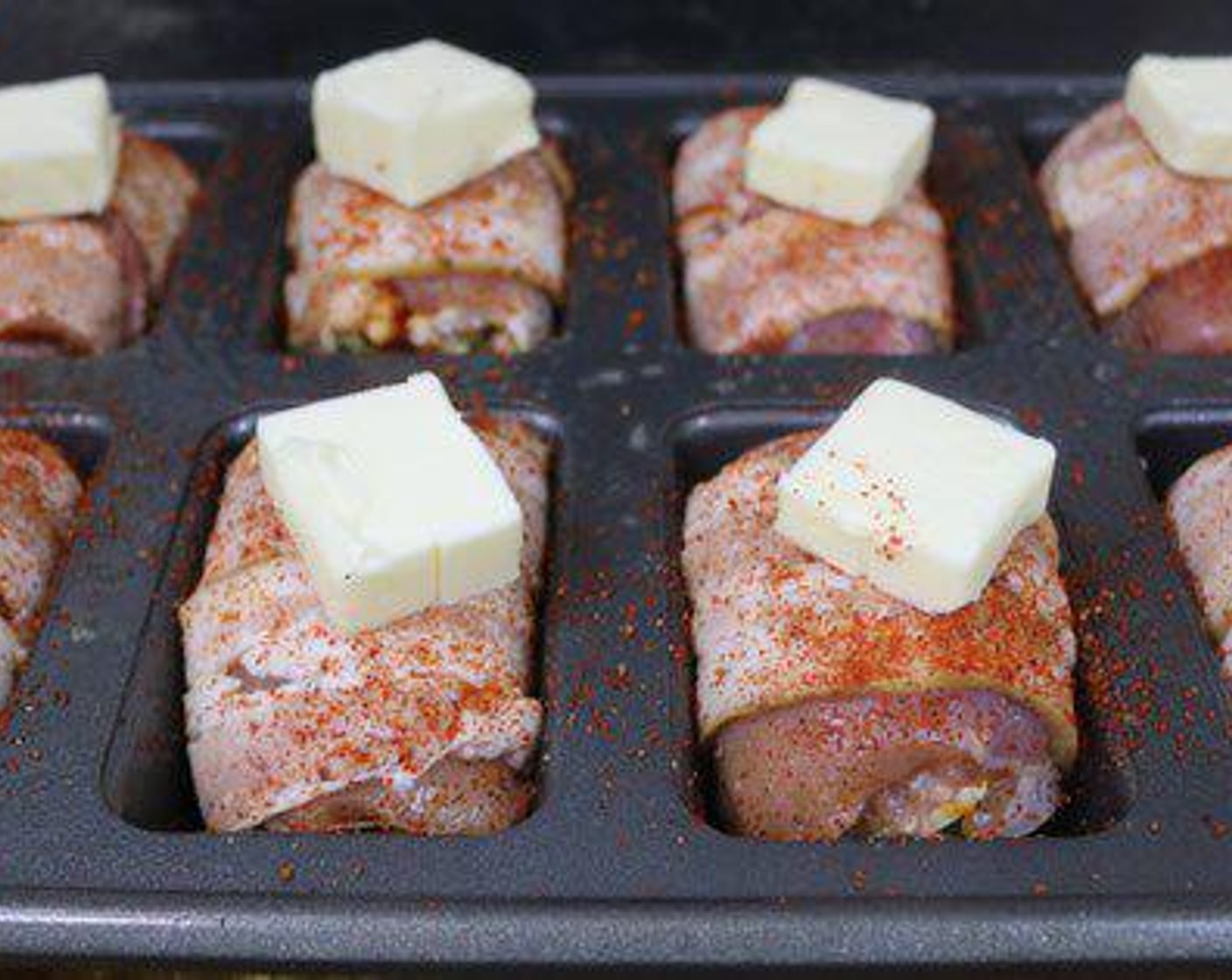 step 4 Spray a pan with cooking spray and place each thigh upright in the pan. Season the thighs with a little barbecue rub and place a tablespoon of Butter (1 stick) on each one. Place in the center of the smoker running at 300 degrees F (150 degrees C).