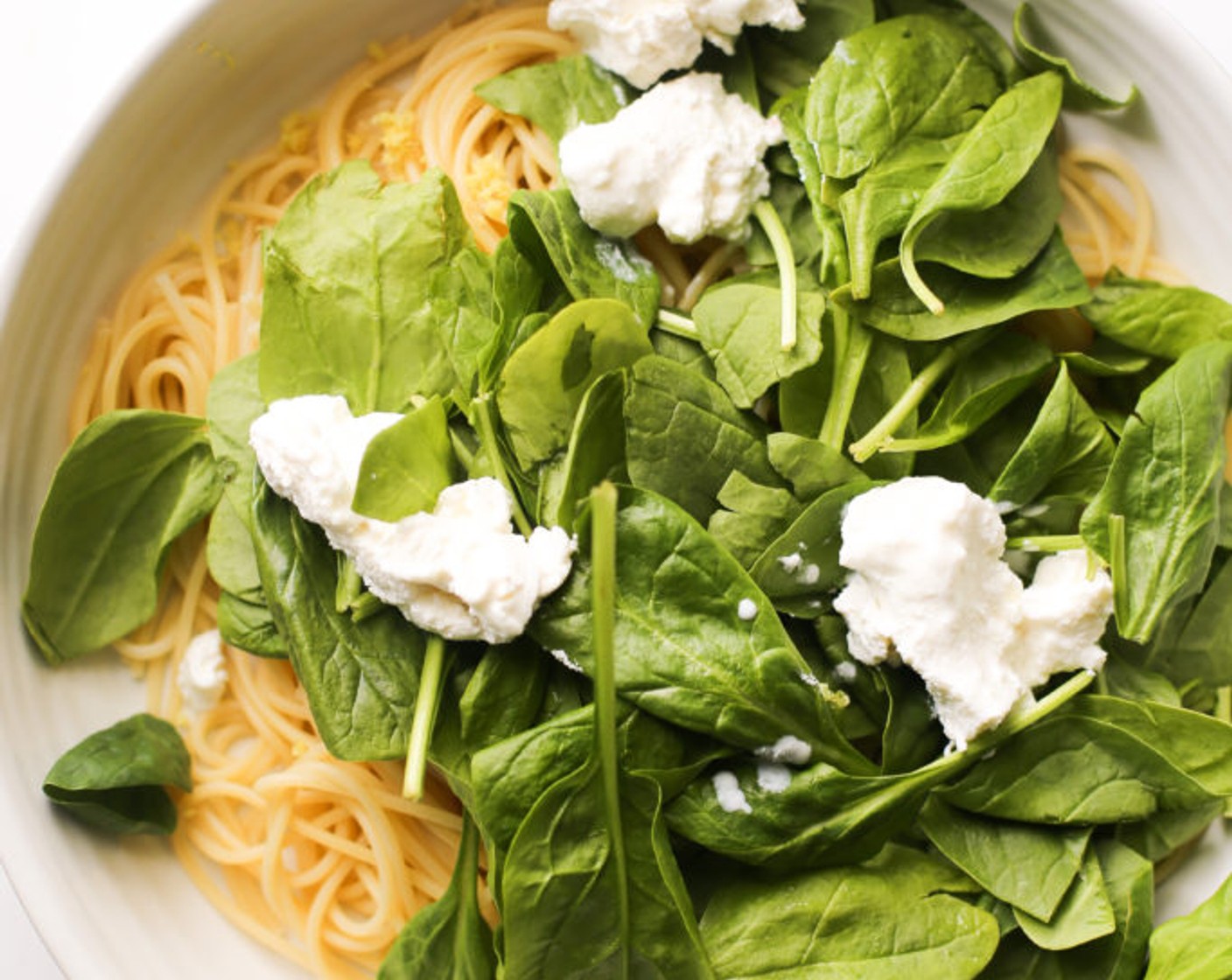 step 7 Reserve 1 cup of pasta water and discard the remaining water. Add the hot pasta to a large bowl. Add Fresh Spinach (2 cups), the zest of a Lemon (1), and Ricotta Cheese (1/2 cup). Add the pasta water, a 1/4 cup at a time, and mix. The spinach will slightly wilt and the ricotta will begin to create a creamy sauce. Add more water as needed. Add more ricotta to your liking.