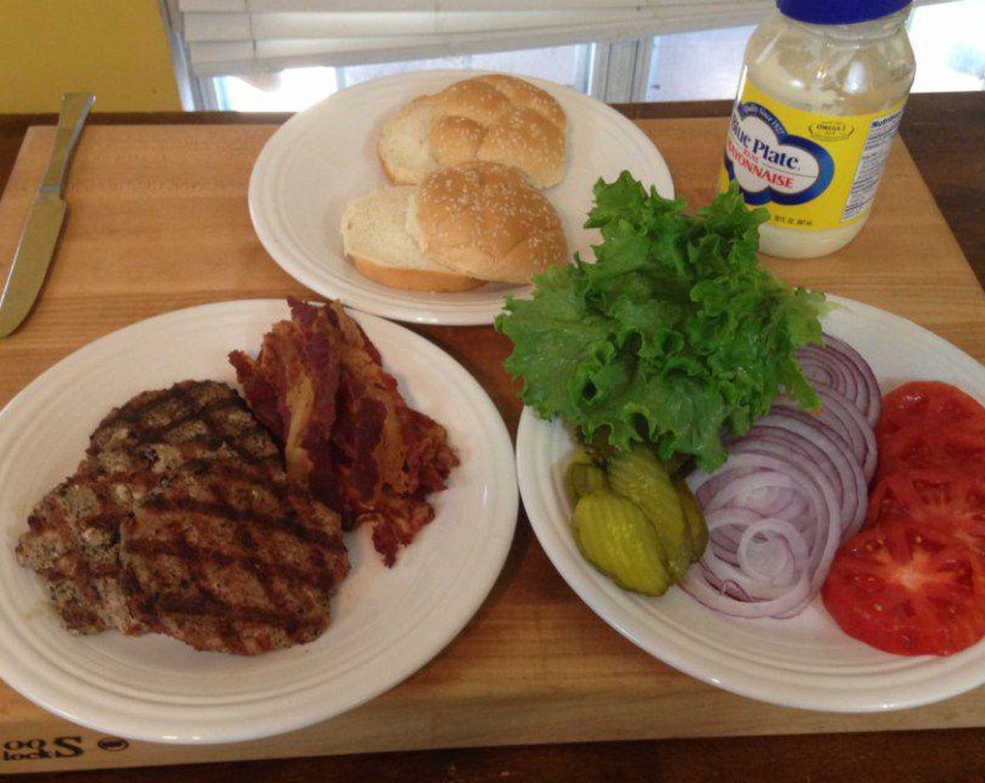 step 4 Once the pork burgers are grilled, it’s time to assemble using Beef Bacon (8 slices), Sesame Hamburger Buns (4), Mayonnaise (to taste), Tomatoes (to taste), Onions (to taste), Lettuce (to taste), Pickles (to taste). Serve and enjoy.