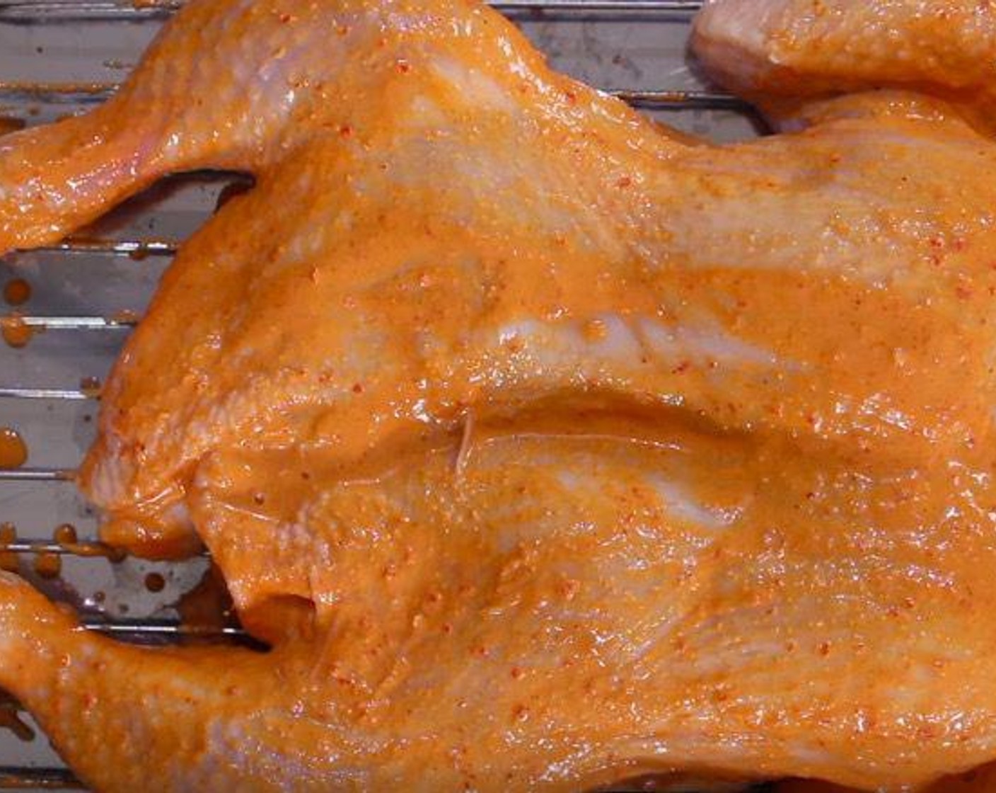 step 5 Place the chicken on a wire rack over a deep baking tray. Brush with the peri-peri sauce.