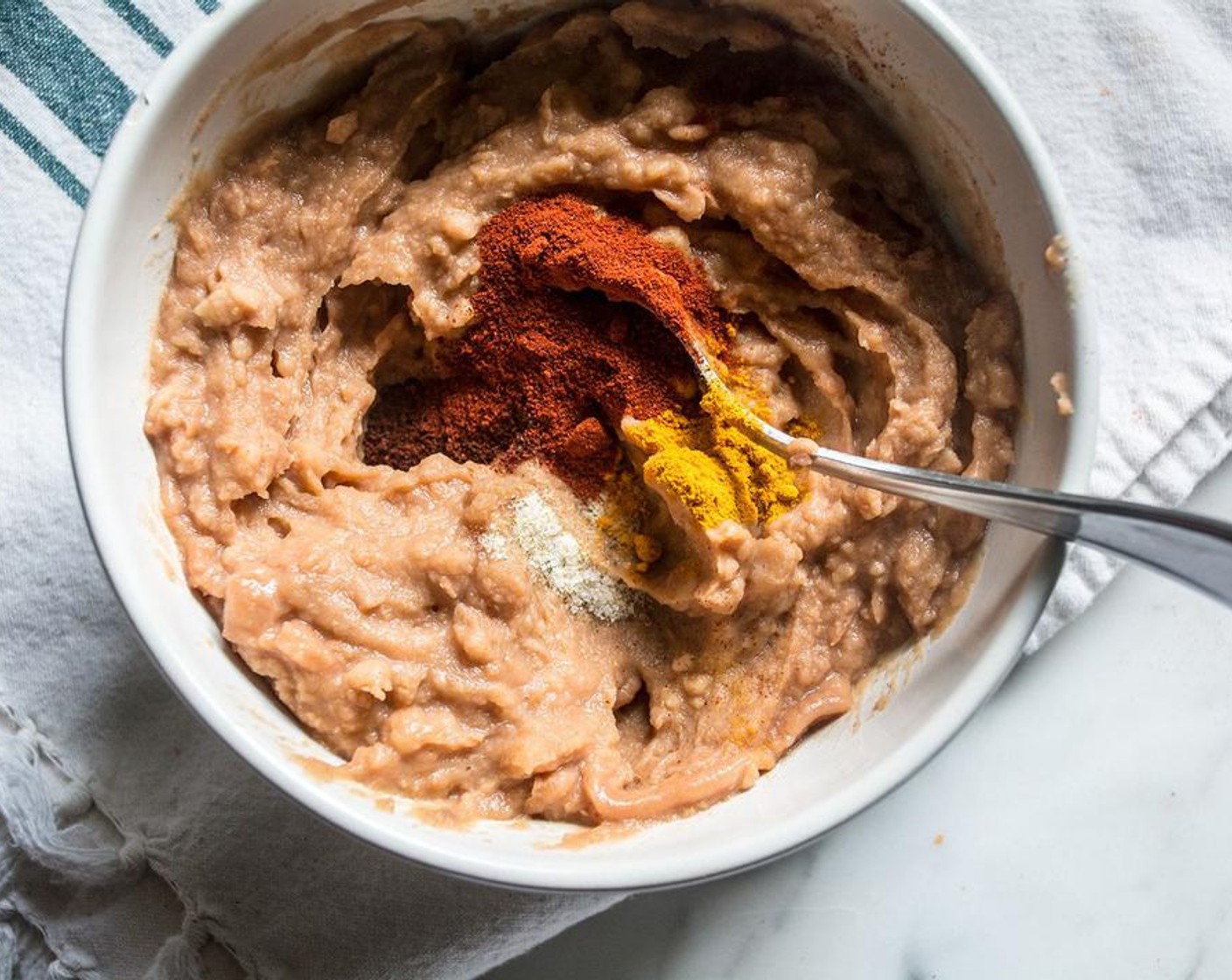 step 4 In a bowl, Stir Chili Powder (1 tsp), Smoked Paprika (1/2 tsp), Ground Turmeric (1/2 tsp), and Garlic Salt (1/4 tsp) into Vegetarian Refried Beans (1 can).