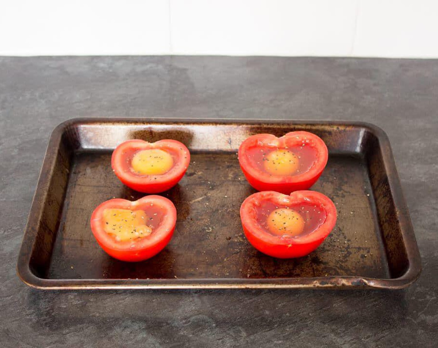 step 3 Place the prepared tomatoes onto a baking tray, crack an Eggland's Best Classic White Eggs (4) into each one then sprinkle over some Salt (to taste) and Simply Organic® Black Pepper (to taste). You may want to be a little cautious when cracking in the egg as there might not be quite enough room for all the white.