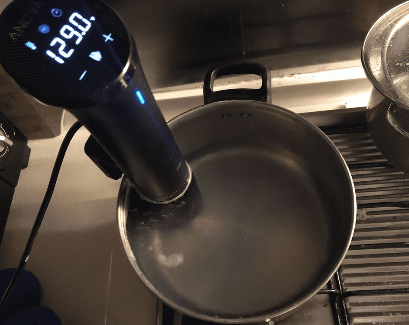 step 2 Fill a pot with water and fasten the sous vide machine to the side. Let the water come up to 129 degrees F (54 degrees C).