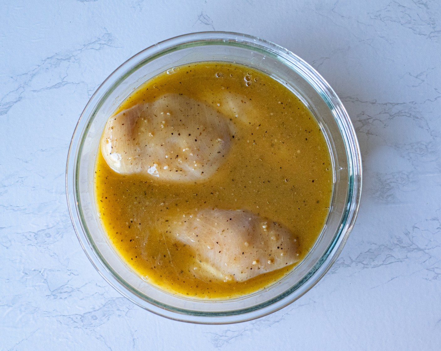 step 2 In a baking dish, lay your Boneless Chicken Breasts (4) and pour the Lemon Pepper Marinade (6 oz) over the breasts.