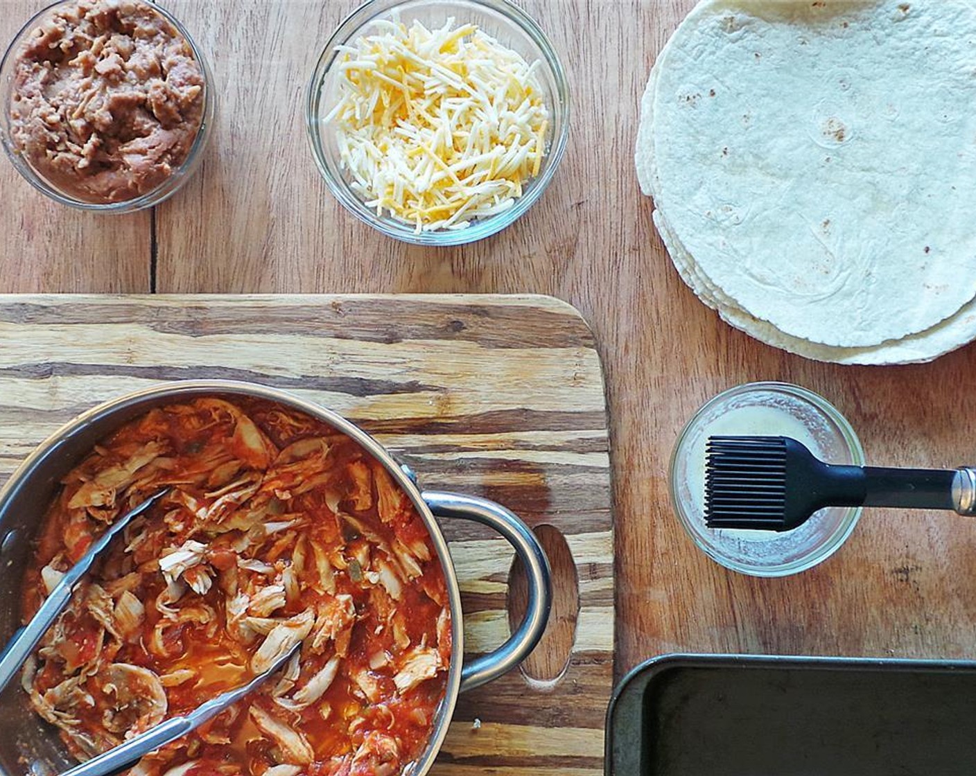 step 4 Place Refried Beans (1 can) in a microwave-safe bowl and microwave 1 minute. Remove chicken from stove and set up folding station with Flour Tortillas (8), refried beans, Monterey Jack Cheese (1 cup), and rotisserie chicken.