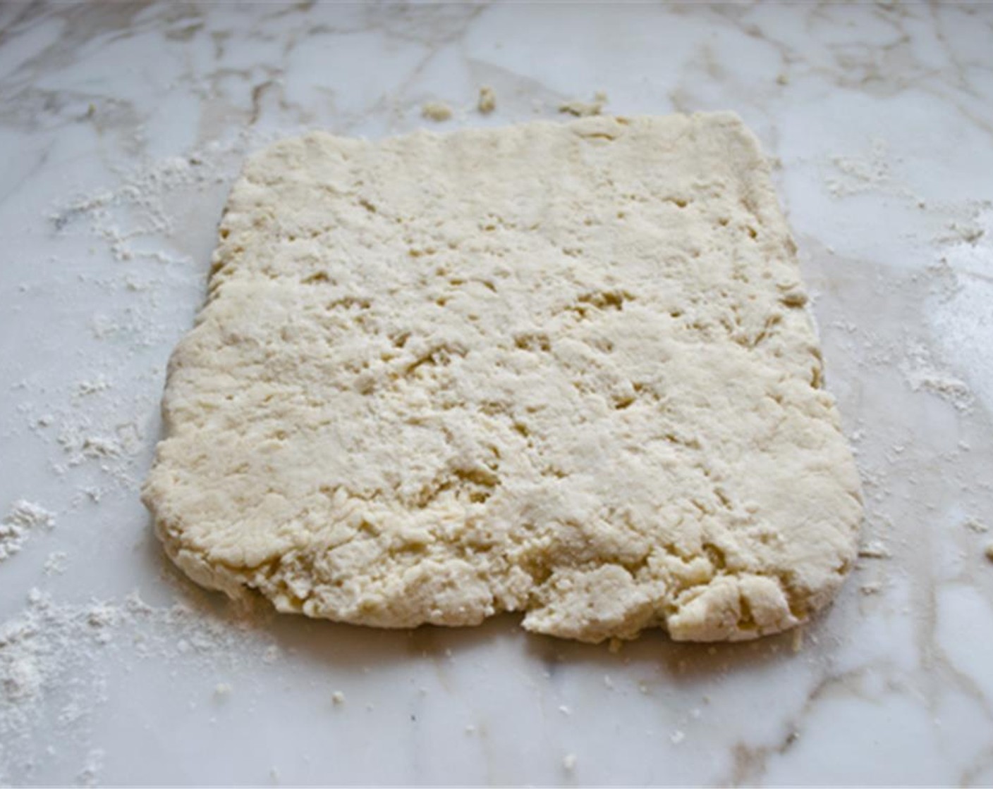 step 5 Turn the dough out onto a lightly floured work surface. Dust the top of the dough with a bit more flour and bring together gently into a loose ball. Pat the dough into a 3/4 inch thick rectangle.